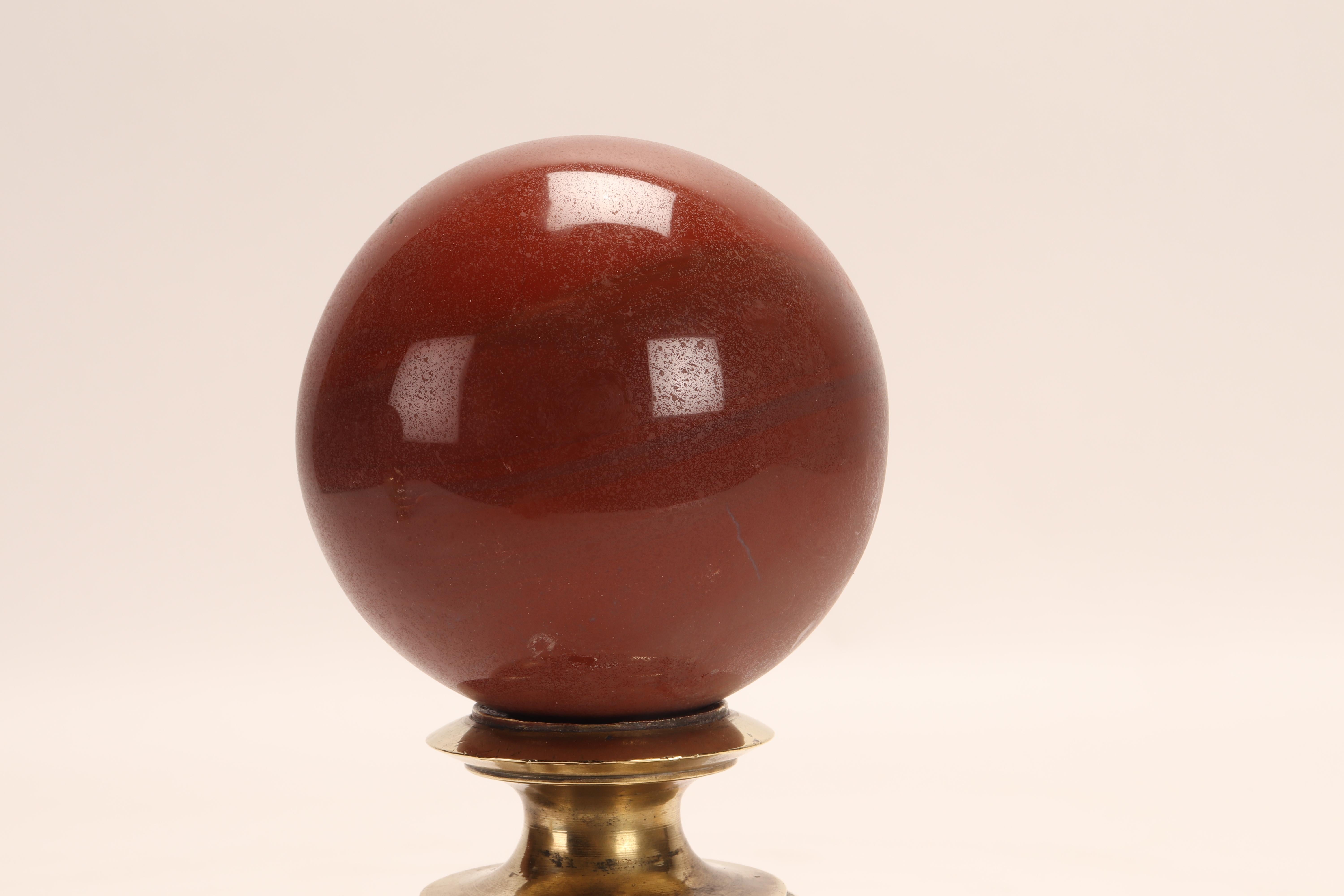 Auf einem Sockel aus Messing ruht eine Kugel aus rotem Jaspis, die eine vasenförmige Stütze mit einem gewellten Profil hat, die sich mit einer konkaven Platte nach oben öffnet. Italien, um 1870.