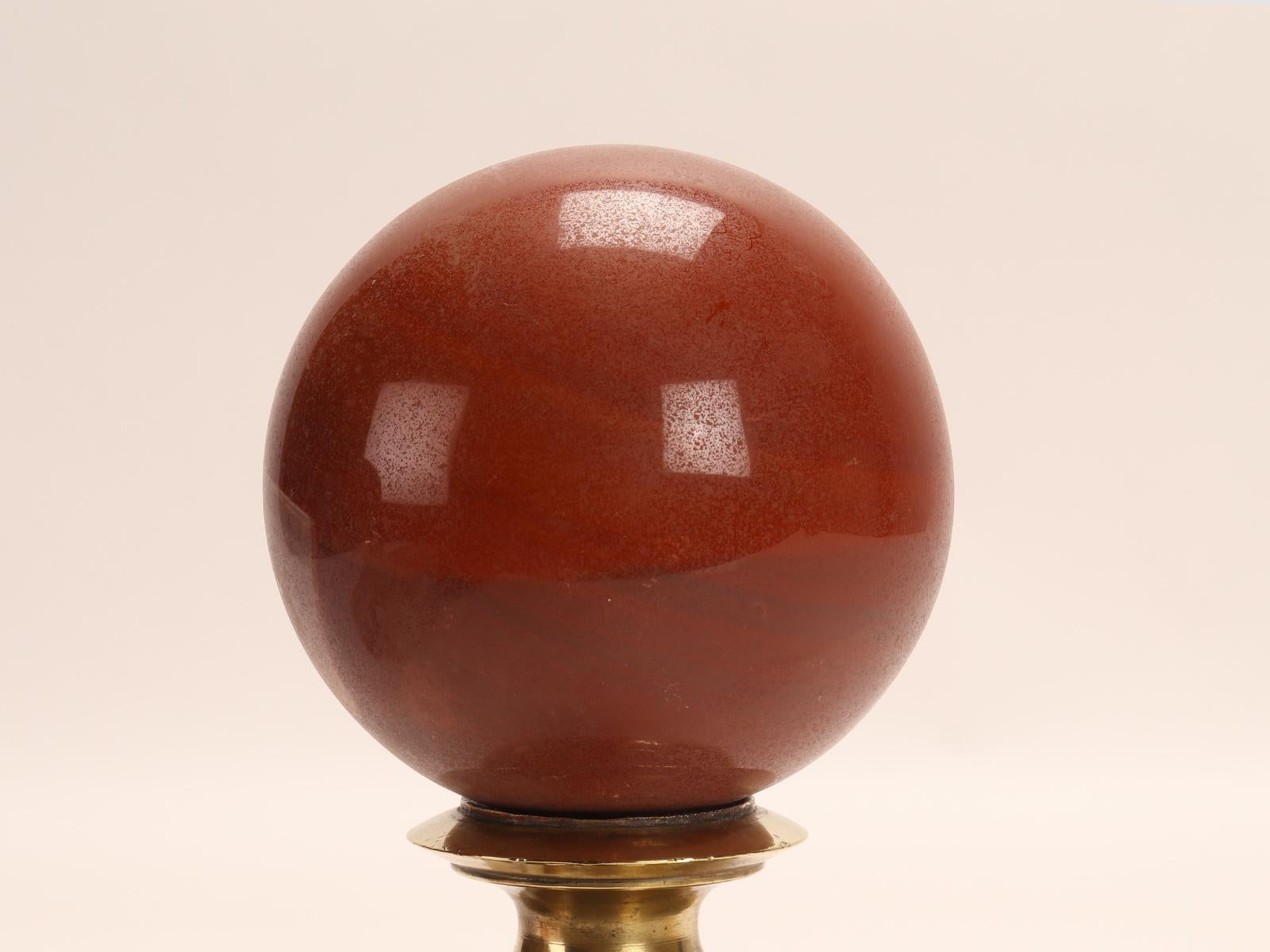 Brass A sphere of red jasper, mounted on a brass base, Italy 1890. For Sale