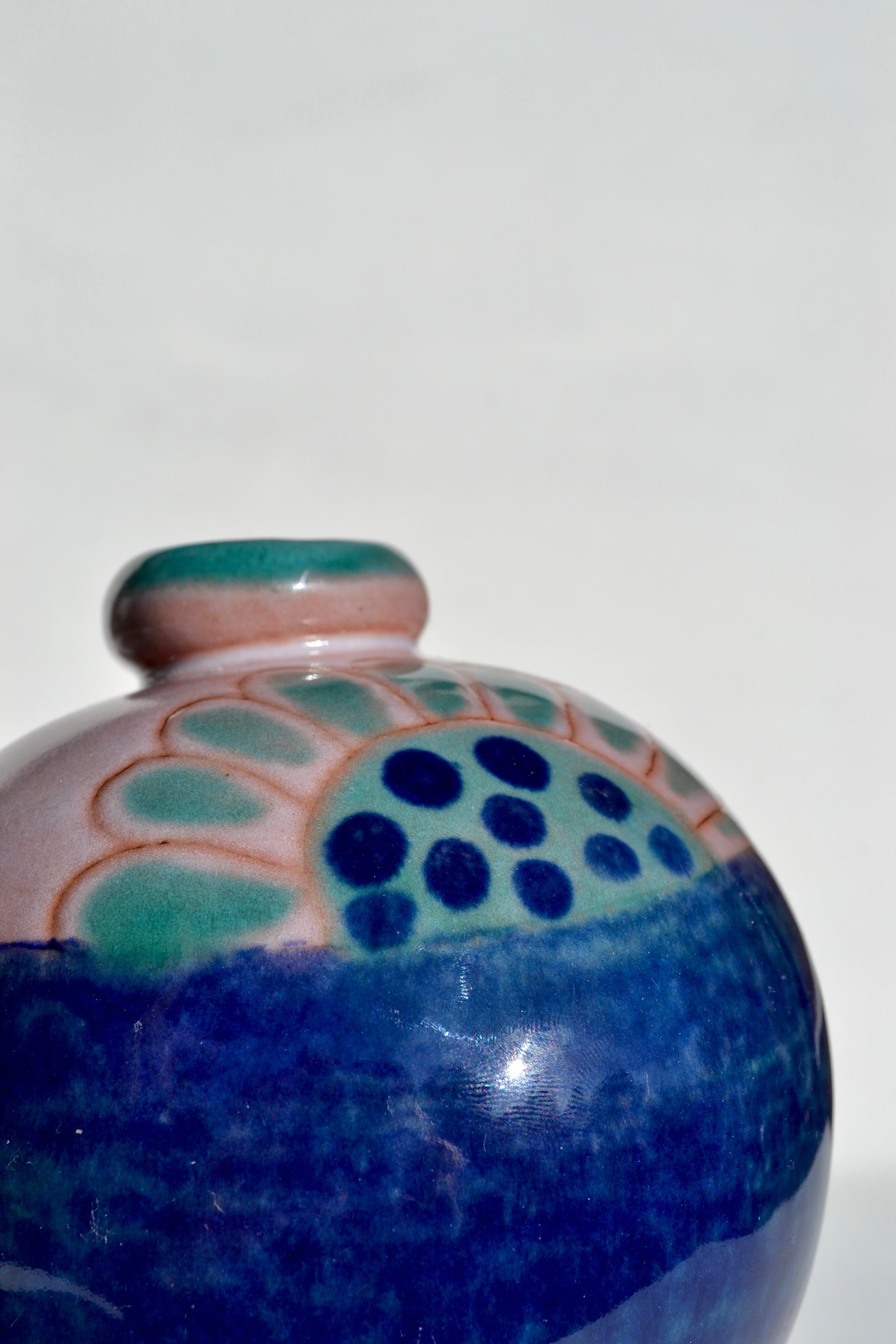 Elegante vaso in ceramica di Robert and Jean Cloutier, Francia, circa anni '70.
La forma perfettamente arrotondata è esaltata da un vivace decoro smaltato a mano nei toni del blu profondo, del turchese e del rosa malva, che mette in mostra il senso