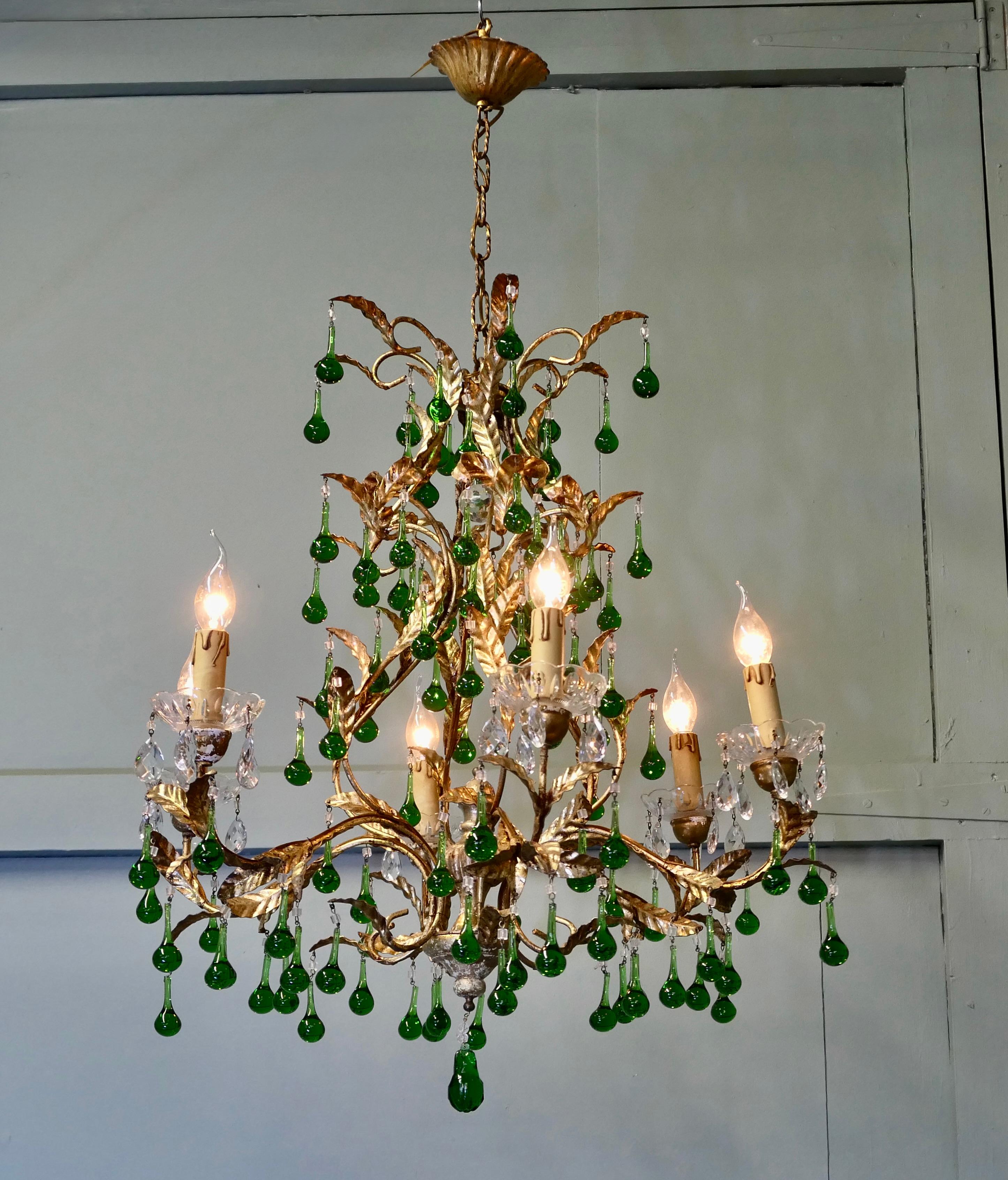 Uno splendido lampadario francese a 6 bracci in verde smeraldo e oro

Si tratta di un pezzo di grandi dimensioni di eccellente qualità, le foglie di toleware hanno una brillante finitura dorata e formano una gabbia aperta a cui sono appese numerose