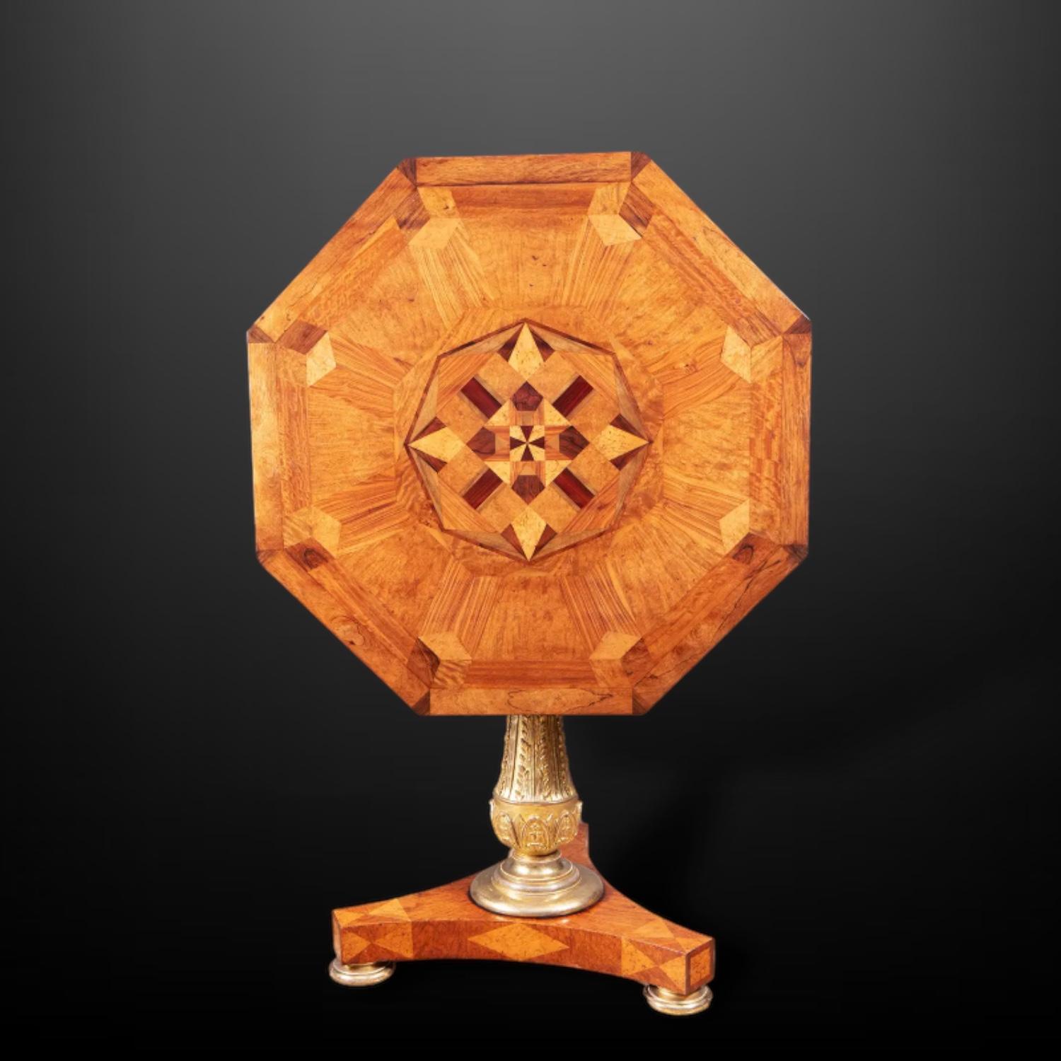 A splendid late Regency parquetry specimen top centre table, stamped S. Jamar, the octagonal tilt-top veneered in various woods with a geometric design, raised on a gilt composition stem and a triform base.
