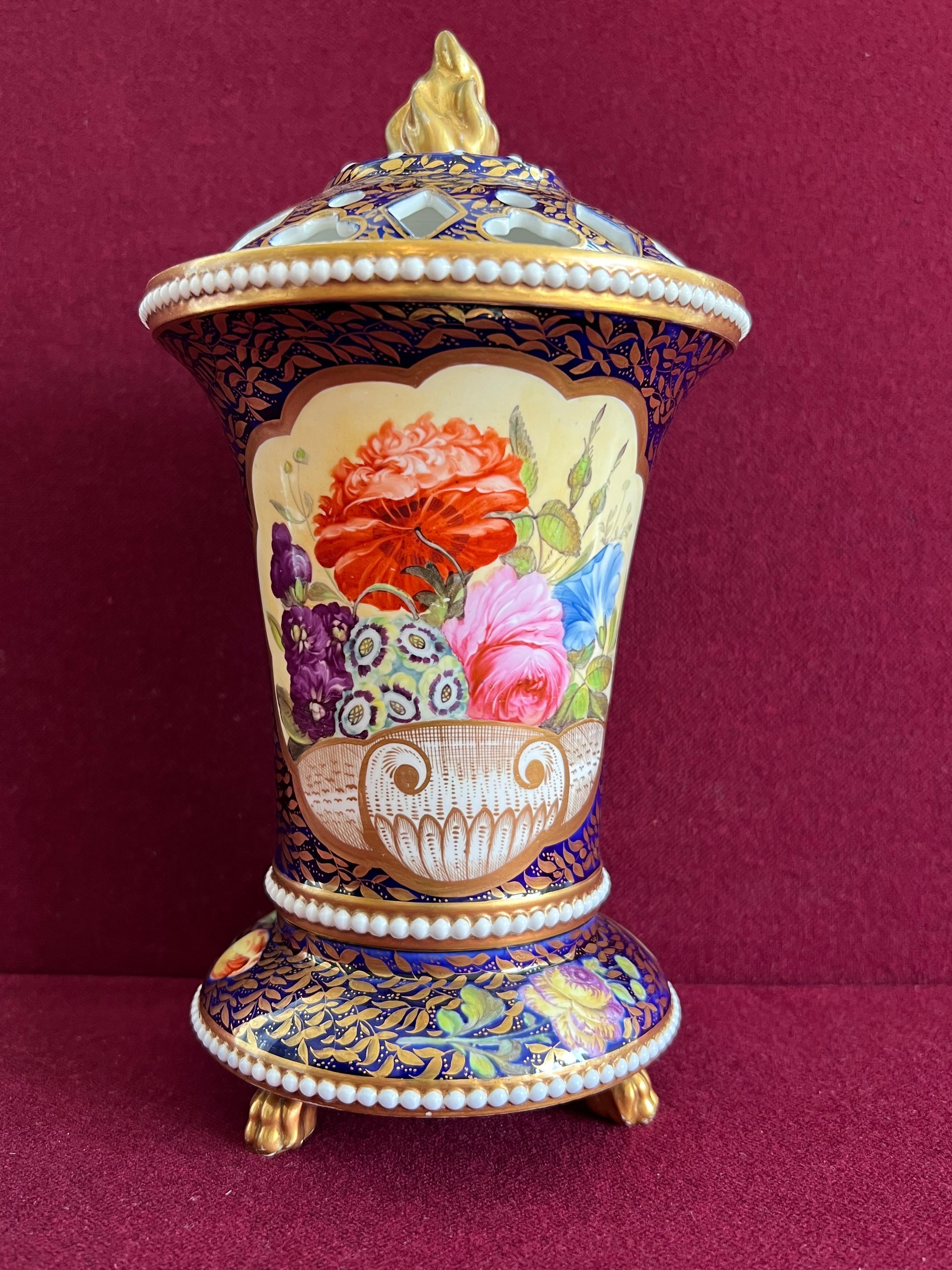 Un vase Pot Pourri en porcelaine Spode avec des perles vers 1820-1825. En forme de trompette évasée, estampée de trois bandes de perles, reposant sur trois pieds pattes dorés, le couvercle percé avec un fleuron flamiforme. Richement décoré selon le