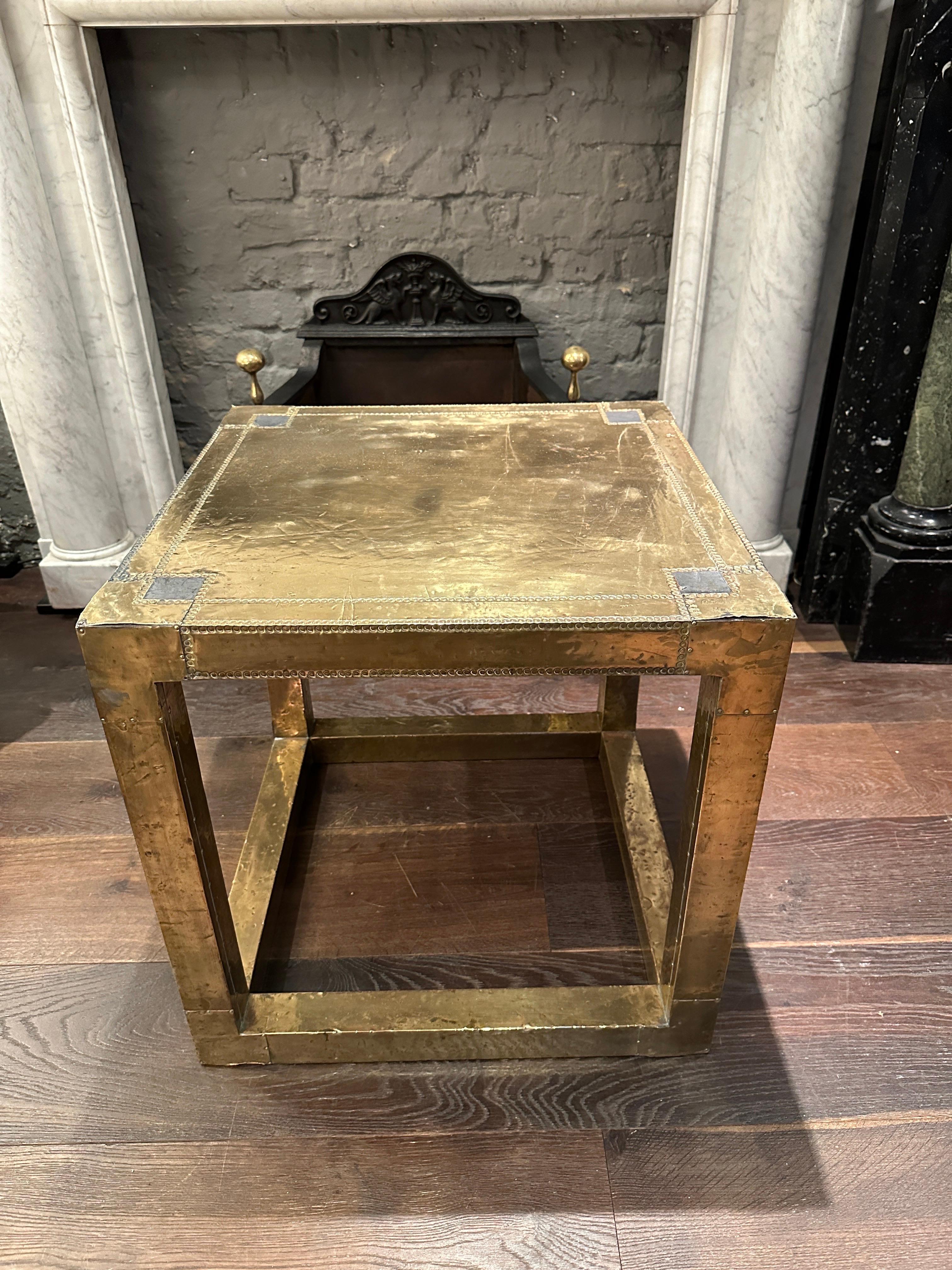 A Brass cubed end, side or coffee table in beaten riveted brass. Open sided, good usable size and aged worn patina. Signed by the Artist R Dubarry Marbella 