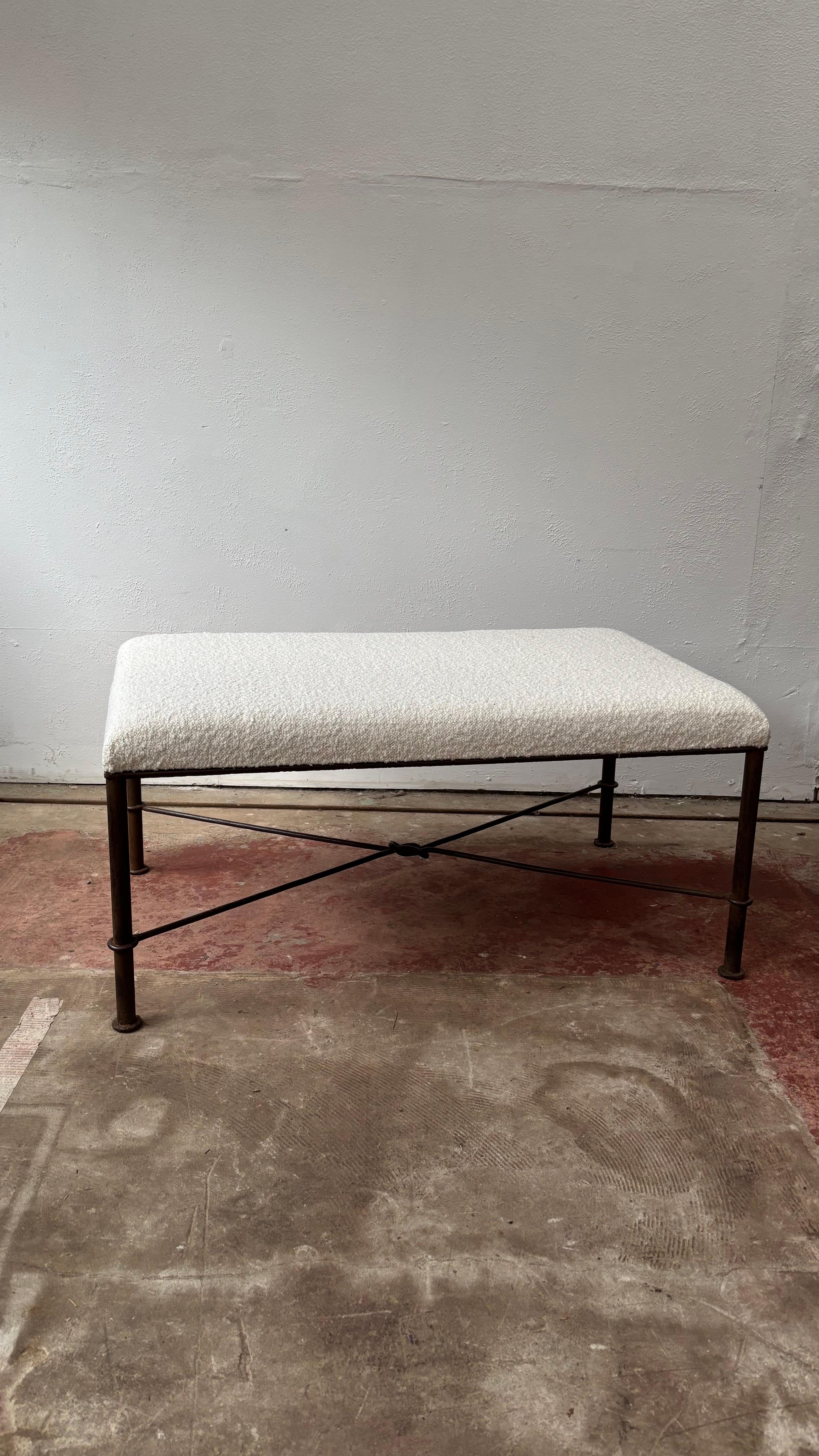A wonderfully chic iron bench seat that would work as a footstool / dressing room stool / hall bench / centre stool. 
The iron is beautifully forged with ring turn legs and four thinner undertier wires that come together in a knot at the