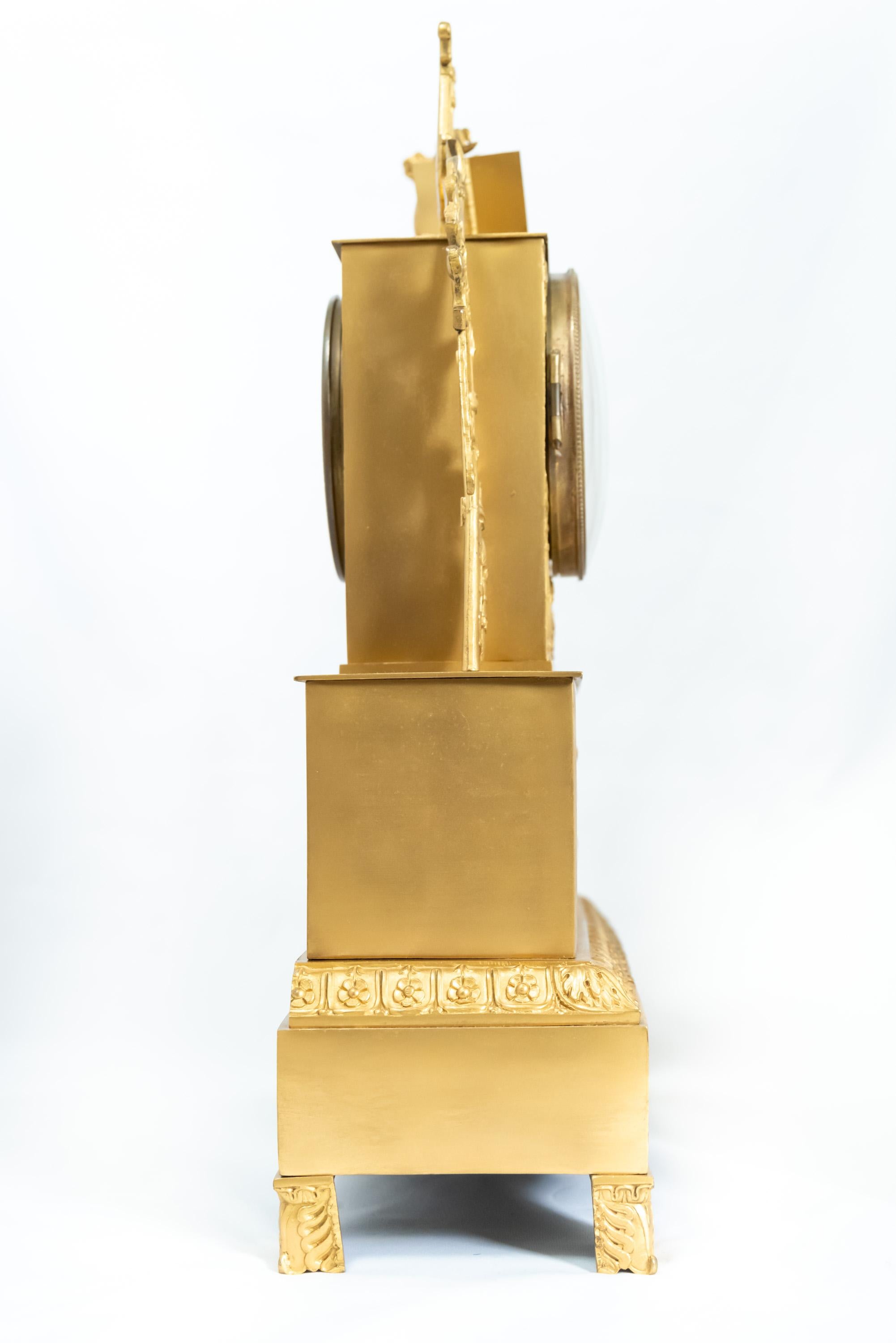 Pendule française en bronze doré représentant un personnage debout, époque Restauration, 1815-1830. Le mécanisme à fil de soie est en bon état de fonctionnement avec la clé et le pendule.