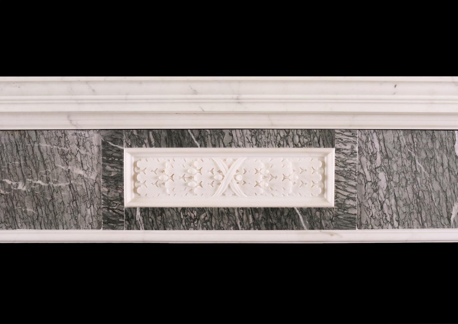 A good quality English marble fireplace in the late Georgian manner. The jambs and frieze in a green Vert d'Estours marble with carved white Statuary marble fluted brackets. The frieze with central panel with carved leaves, ribbons and berries.
