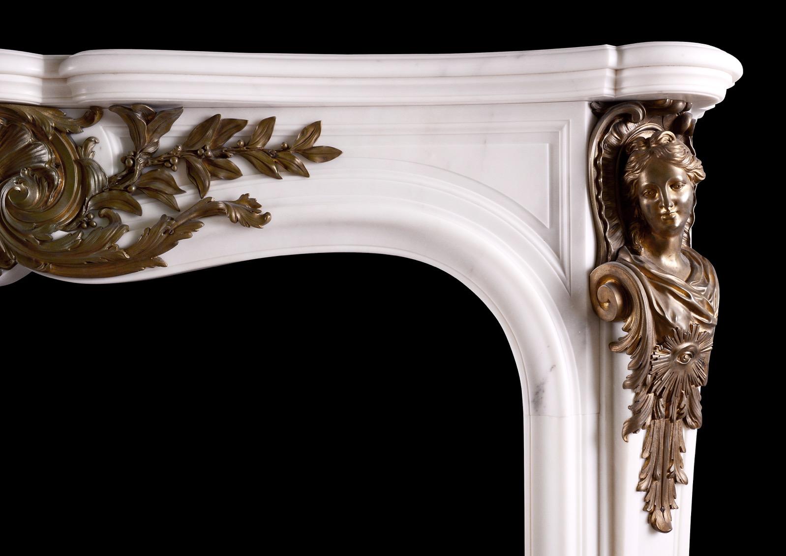 A very fine quality Statuary white marble fireplace with bronze ormolu enrichments. The moulded, panelled jambs with brass busts with acanthus leaves below. The shaped frieze with cast shell and foliage to centre. Shaped moulded shelf above. High