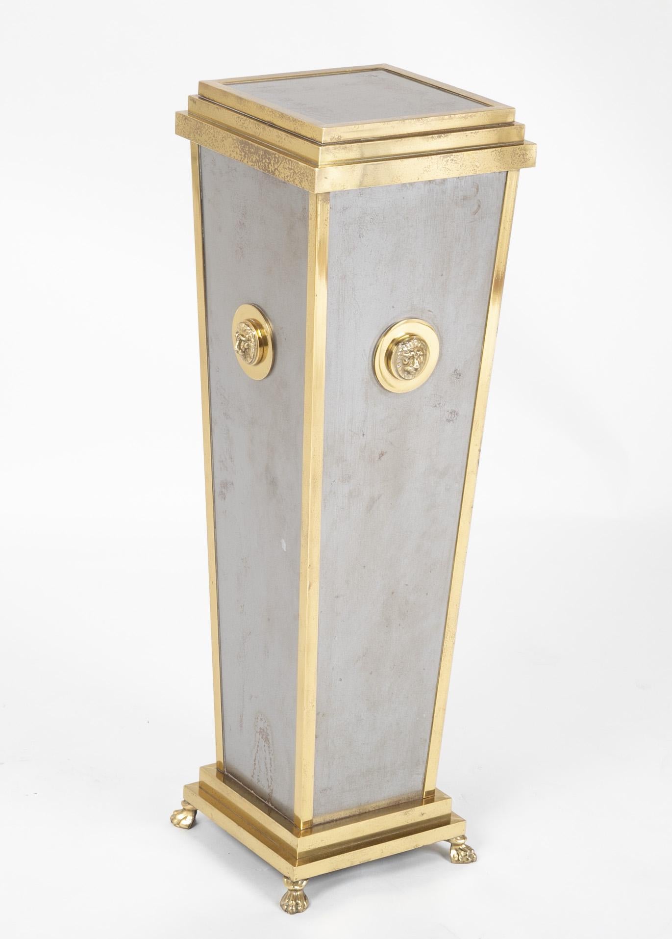 A Maison Jansen style brass and steel pedestal with Lion rosettes rising on paw feet.