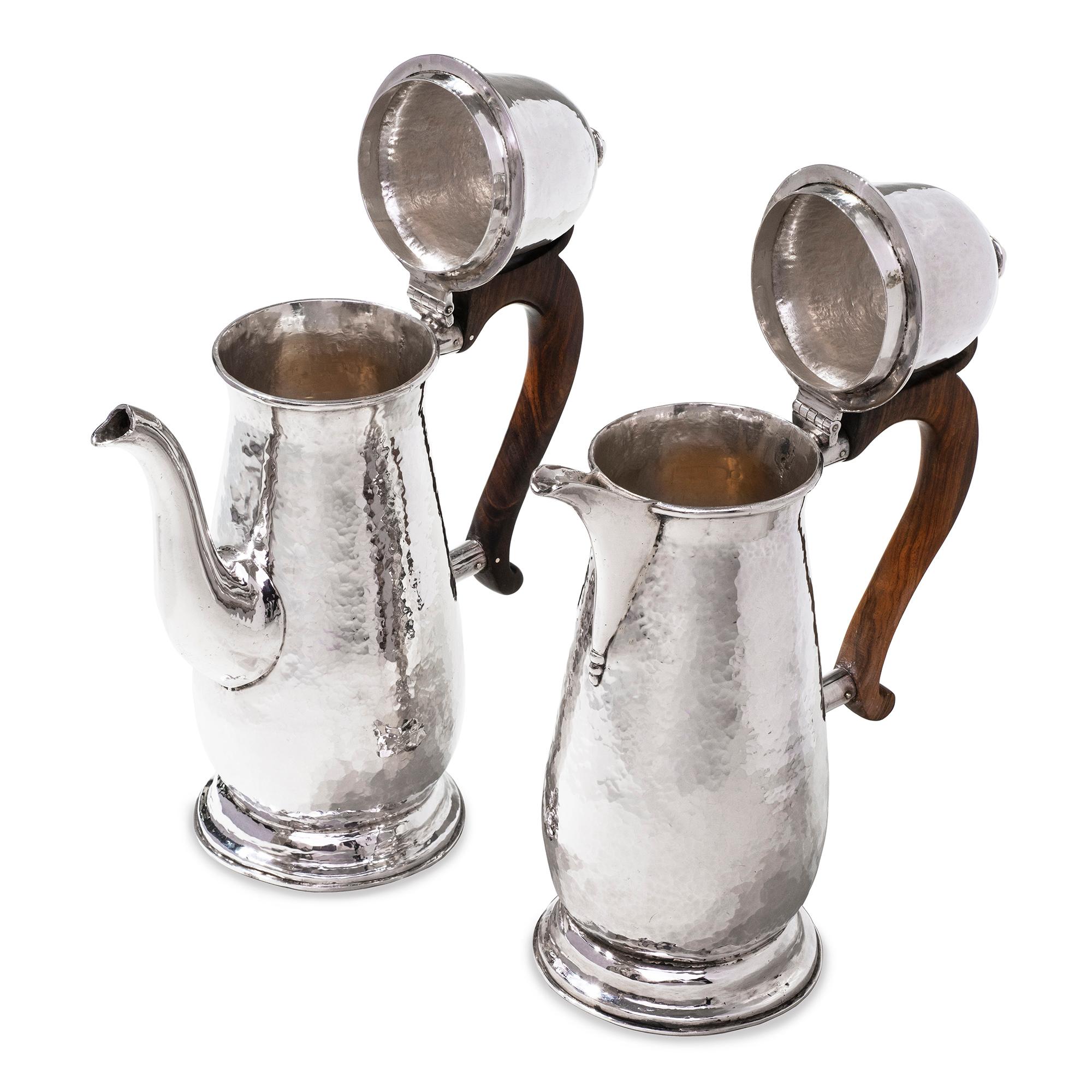 A sterling silver coffee pot and hot water jug, having plannished baluster body, bell domed lid with plain finial, and plain spout, brown wooden handle, sitting on round plannished pedestal foot, total weight 40ozs, height 10