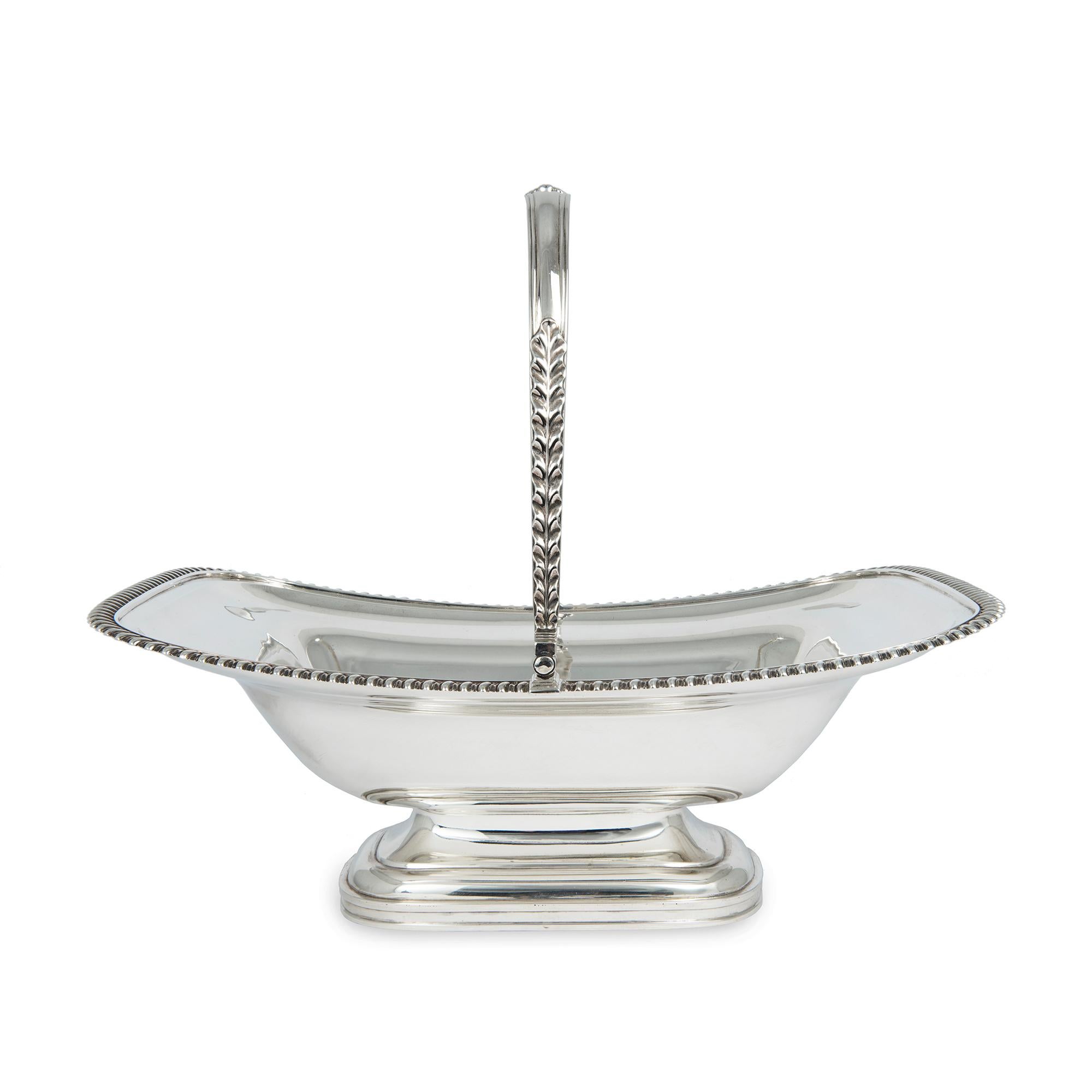 A sterling silver George IV bread basket, with gadrooned border,the swing handle has applied shell and acanthus leaf decoration, with the centre of the body engraved with an armorial, weight 1,099grms (35ozs), length 32cms (12.5