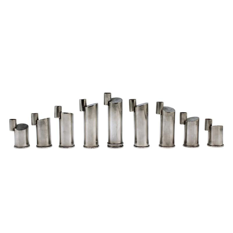 Questa straordinaria lampada di Hanukkah in argento sterling, attribuita alla famosa argentiera israeliana Ilana Rappaport, è un esempio magistrale di design ebraico contemporaneo. Composto da nove singoli portacandele cilindrici di diverse altezze,