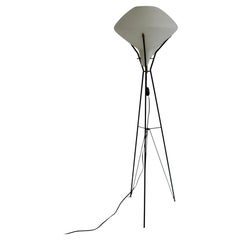 A stilnovo style floor lamp with a metal tripod base