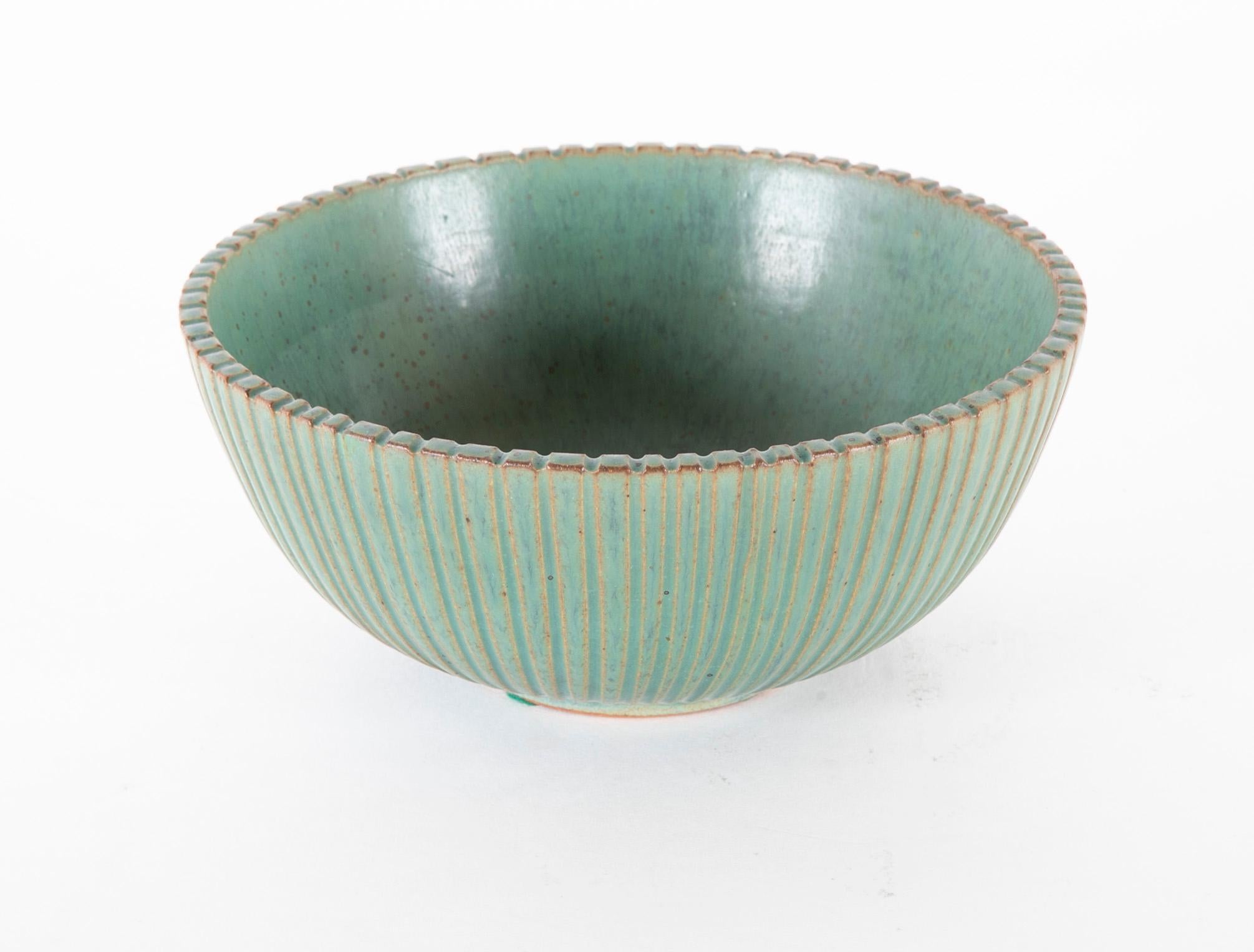 A green glazed and ribbed bowl by Arne Bang. Danish, signed AB and numbered 125 to underside.