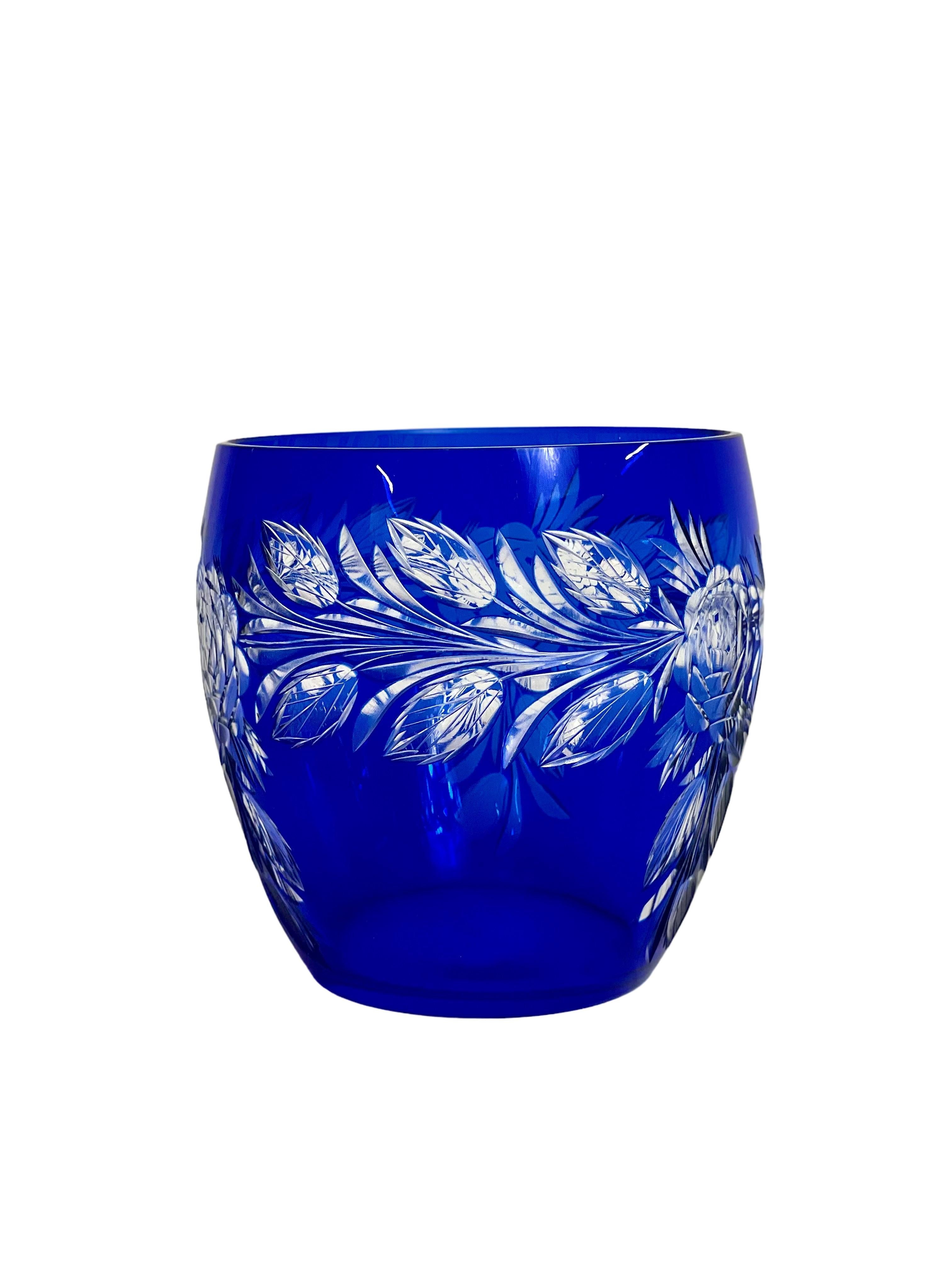 A striking cobalt-blue crystal overlay bowl-shaped vase, cut to clear in an exquisite pattern of foliage sprays all round. The simple design of this piece means it would work well in even the most modern of interiors.