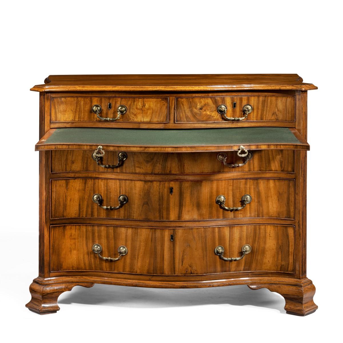 A striking George III serpentine chest of drawers, constructed in oak veneered in coromandel with two short drawers above a brushing slide and three long drawers, the canted corners with stop fluting, original gilt brass castors and handles, all on