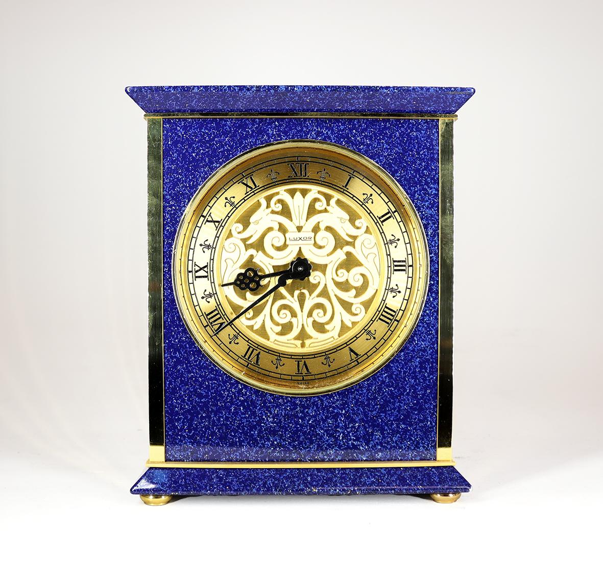 This mid century mantel clock is of exceptional quality, housed in a gilt and enamel case the blue enamelling flecked with gold imitate lapis lazuli. The eight day movement with platform escapement strikes on a bell, made audible through a
