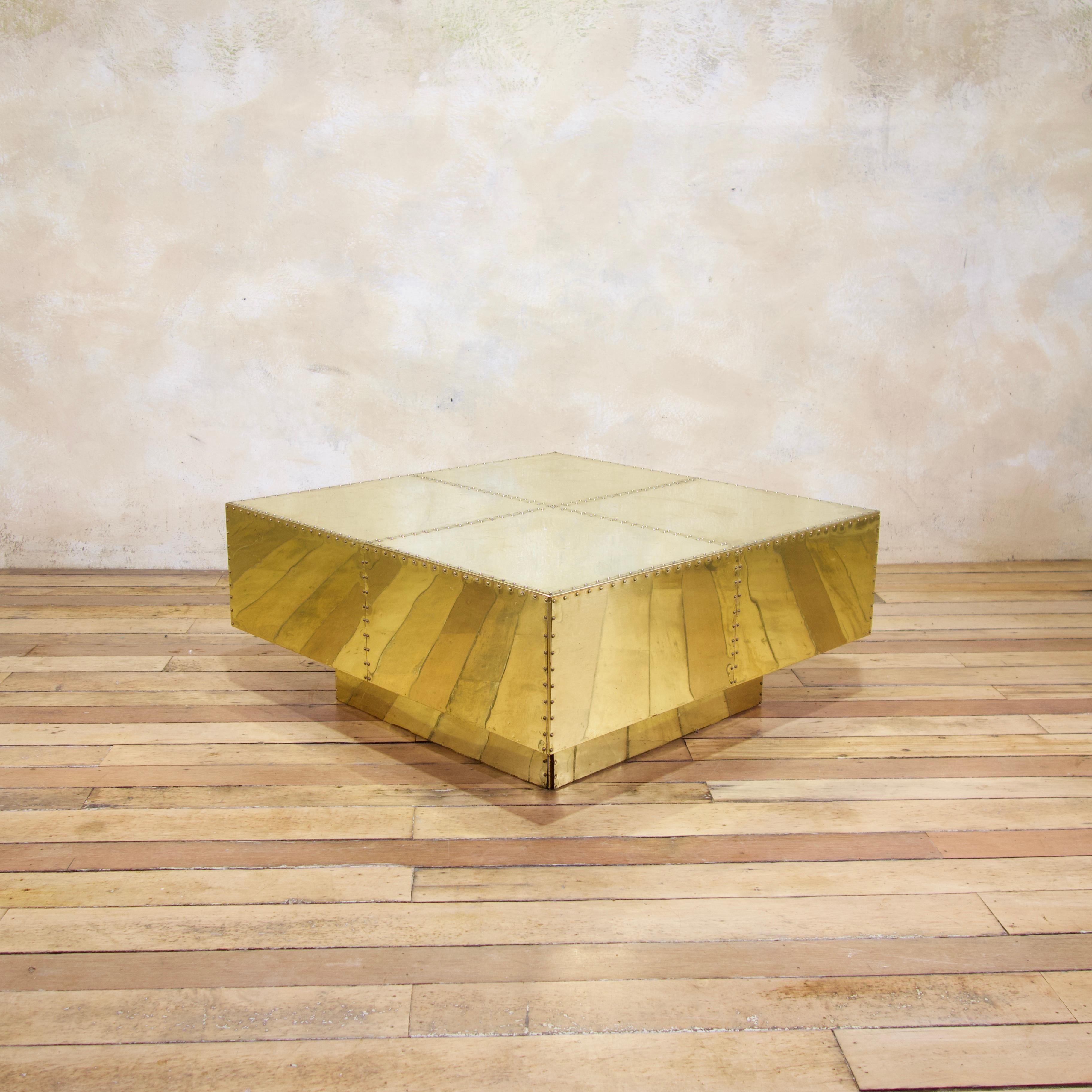 A fabulous Sarreid tiered and studded brass coffee table. Raised on a brass plinth dating from 1970. Featuring four sections to the top, separated by brass studs - which has been carried to each of the sides. 
A very striking design that would grace