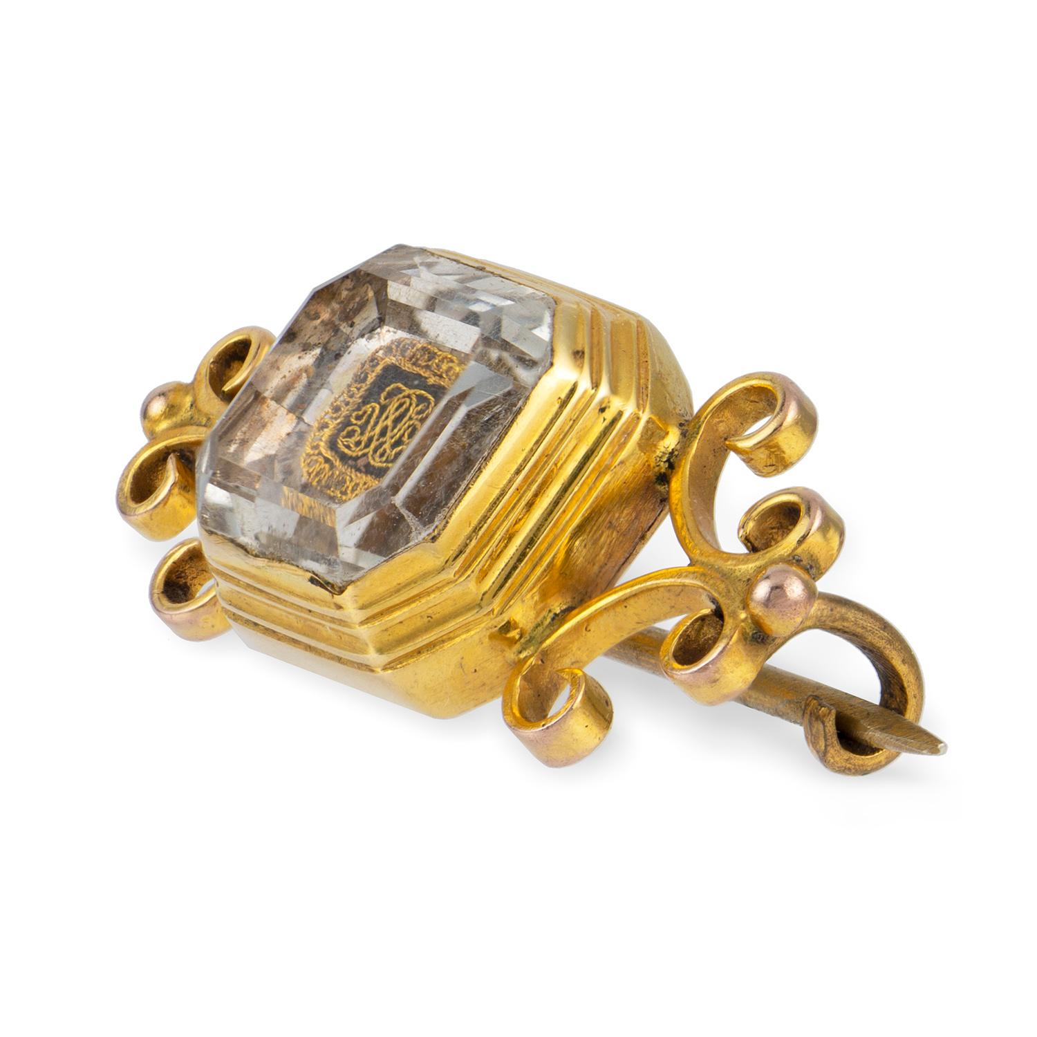 A Stuart crystal and gold brooch, the octagonal faceted crystal with a gold cypher to the back, the reversed cypher with the initials CWC surrounded by a twisted ribbon-like gold-wire decoration that symbolises the eternal love, all in a closed-back