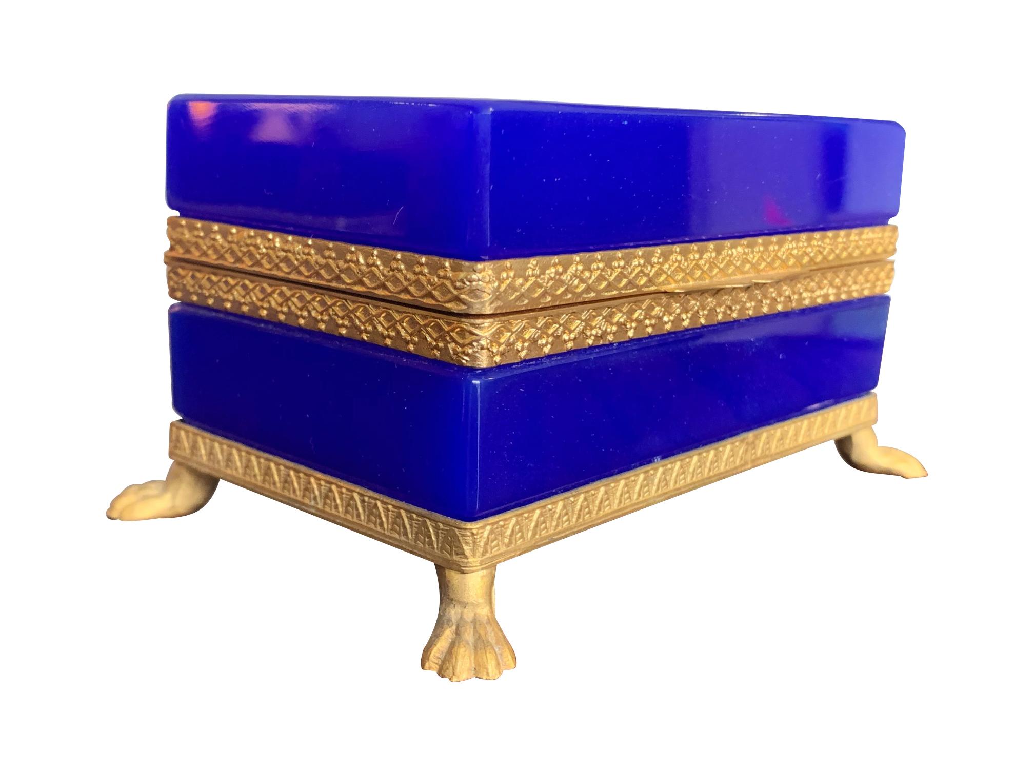 A stunning cobalt blue Murano glass hinged jewellery box by Giovanni Cendese, Murano Italy with gilt central detail and hinge and ornate gilt metal feet.

 