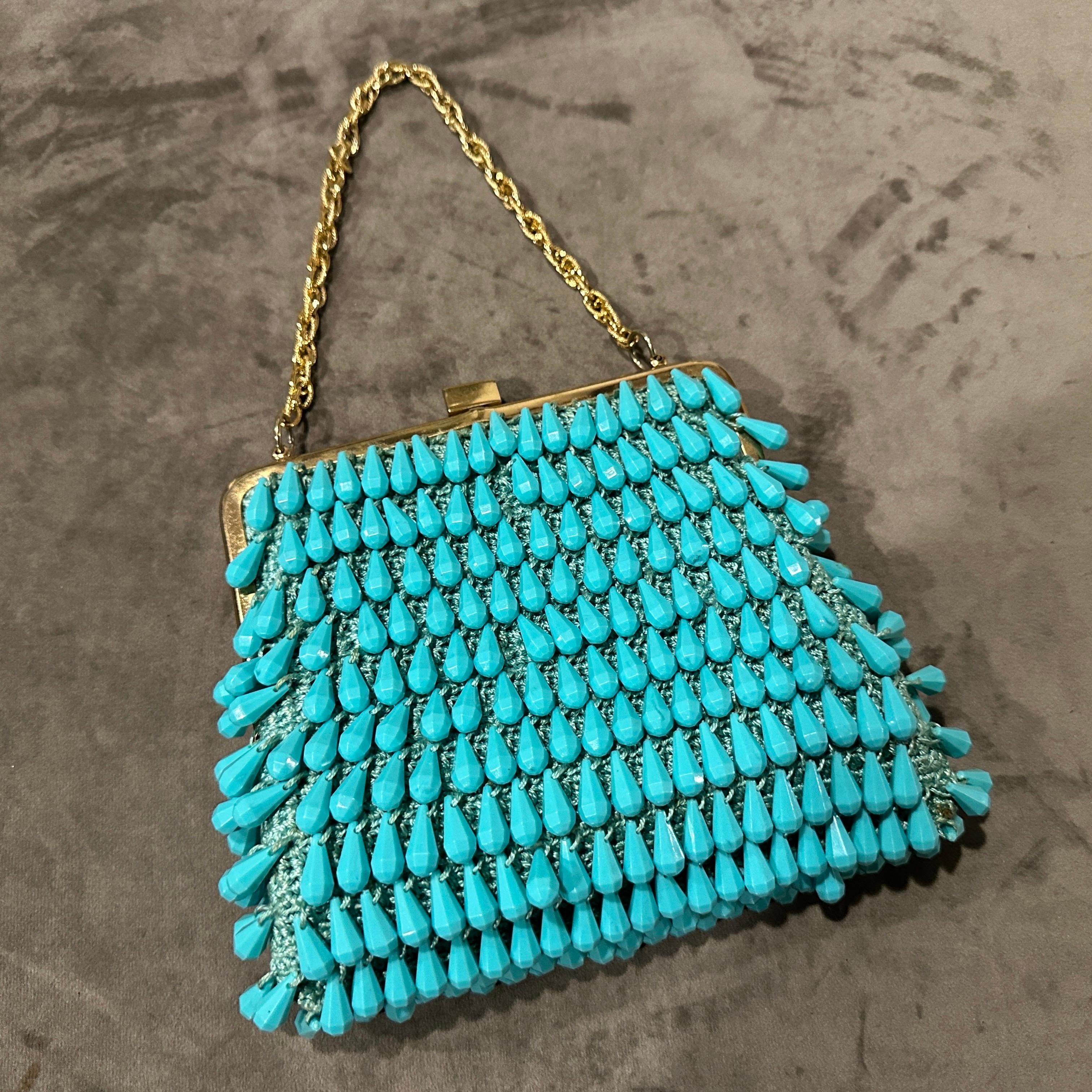 This exquisite vintage evening bag is a true testament to the glamour and craftsmanship of 1960s Italian design.  It's a captivating piece that combines vibrant turquoise resin with elegant brass accents, creating a luxurious and eye-catching
