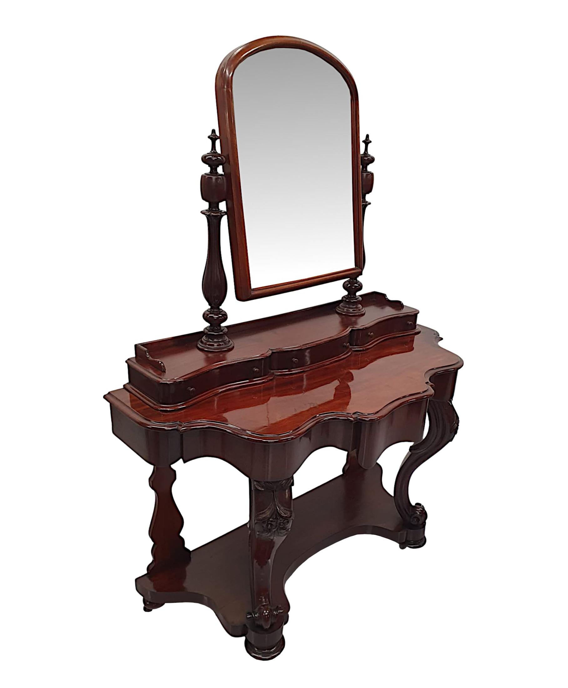 A stunning 19th Century mahogany duchess dressing table of gorgeous quality, finely hand carved with rich patination and grain. The moulded top surmounted with adjustable mirror glass plate of arch top form set within fluted mahogany frame flanked
