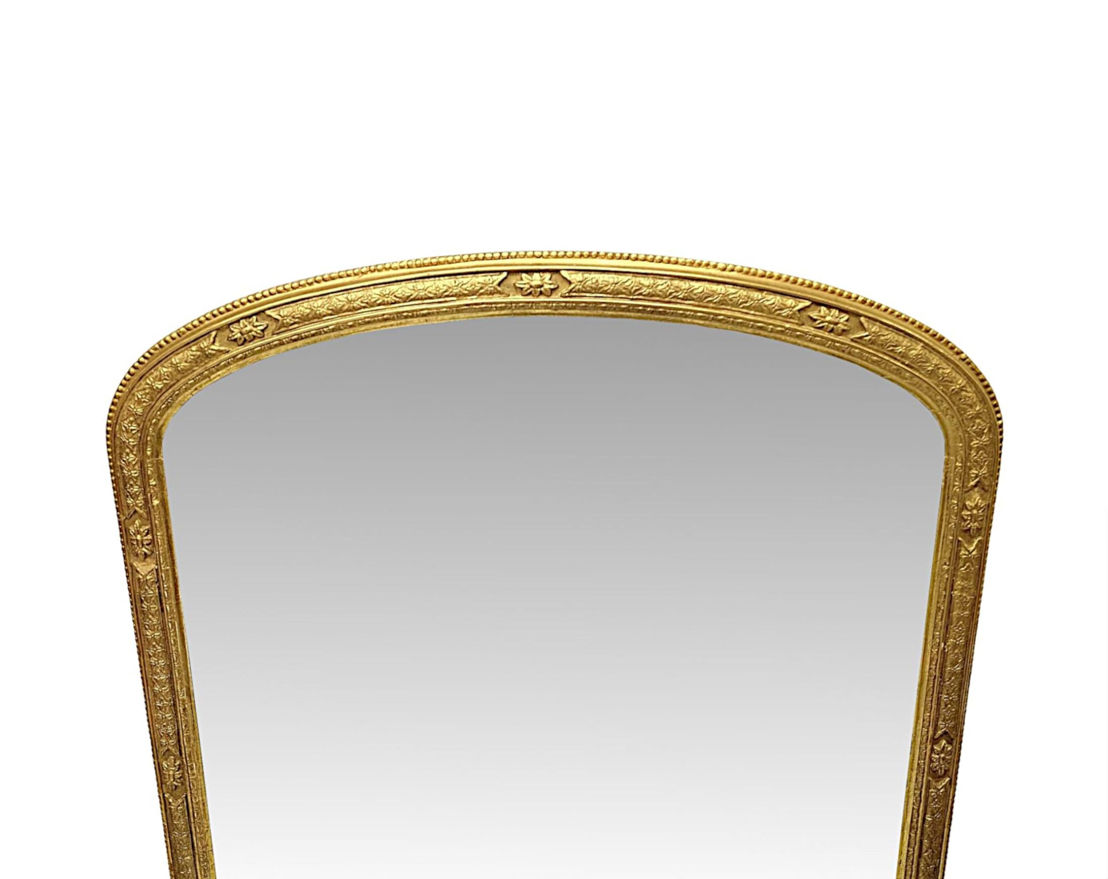 Uno splendido specchio in legno dorato del XIX secolo, elegantemente semplice e di qualità eccezionale.  La lastra di vetro a specchio di forma arcuata è incastonata in una cornice in legno dorato finemente intagliata a mano, modellata e scanalata,