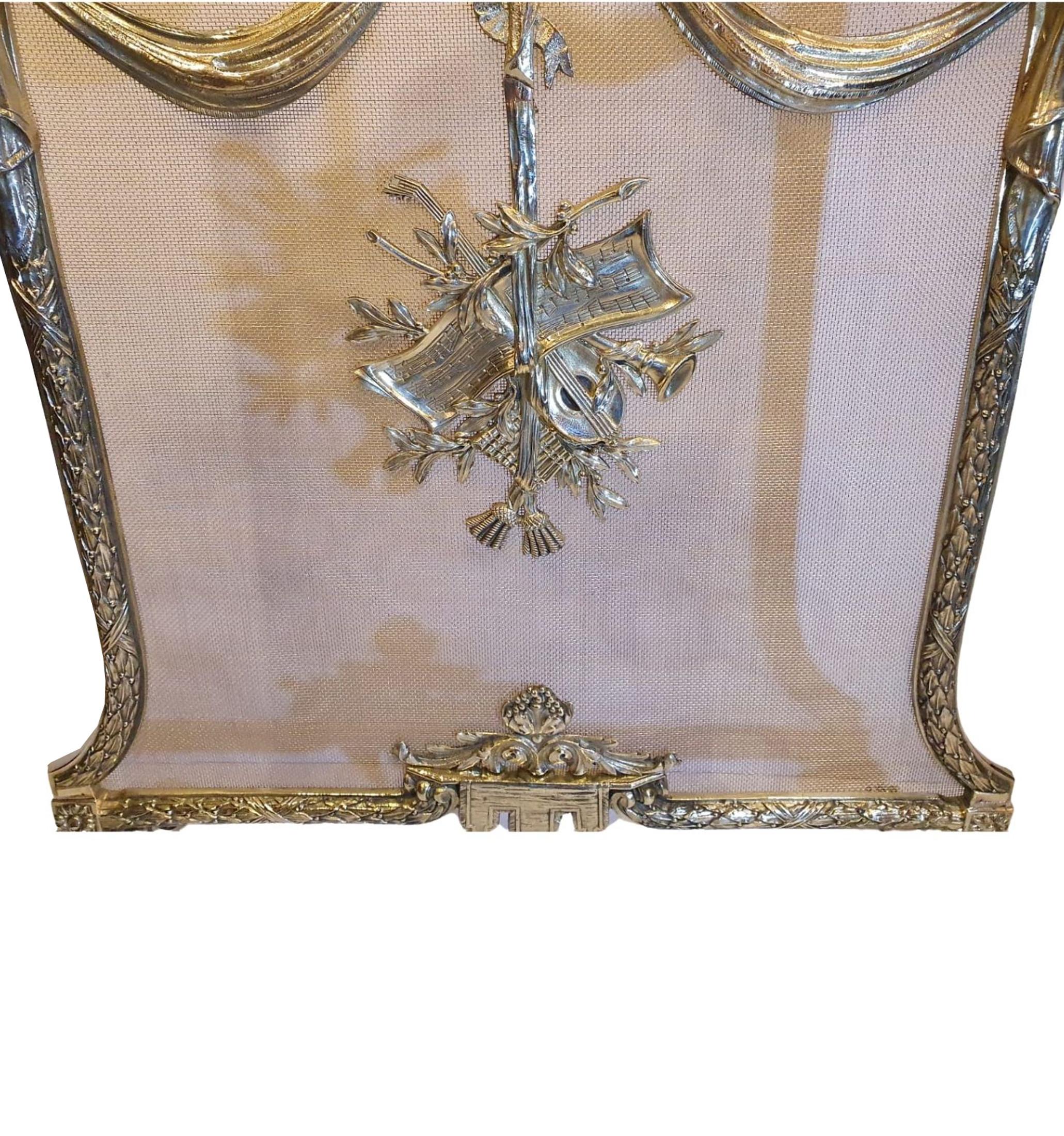 A stunning quality 19th century fully restored polished brass fire screen. The wire mesh of concave form with a beautifully cast frame with finials in the form of grapes and an elegant ribbon bow carrying handle. The wire mesh is adorned with