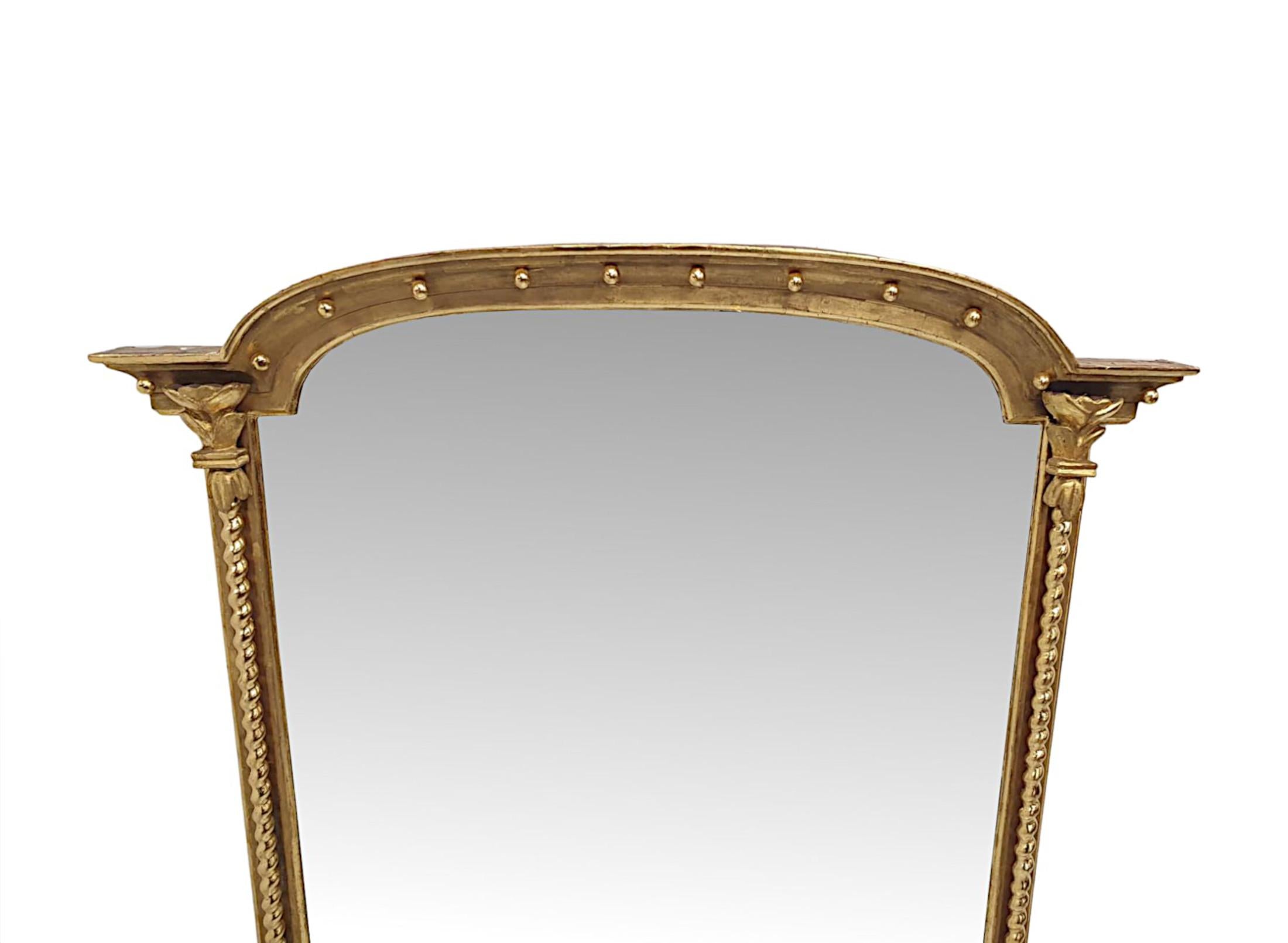 A stunning 19th Century giltwood overmantle mirrorof fabulous quality.  The mirror glass plate of shaped rectangular form set within a finely hand carved, moulded giltwood frame surmounted with fluted and curved architectural overhanging pediment