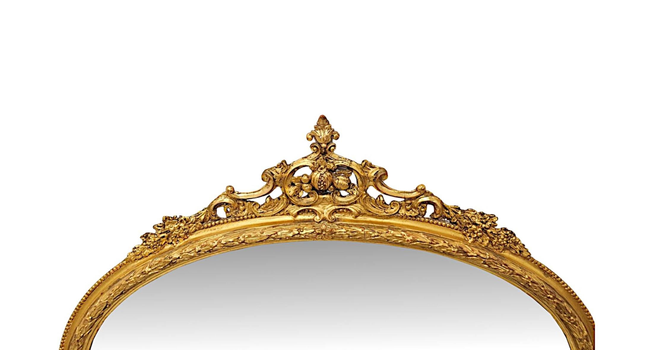 Un superbe miroir à trumeau en bois doré du XIXe siècle, de faibles proportions et d'une qualité exceptionnelle.  La plaque de verre miroir biseautée de forme ovale est placée dans un cadre en bois doré finement sculpté à la main, cannelé et