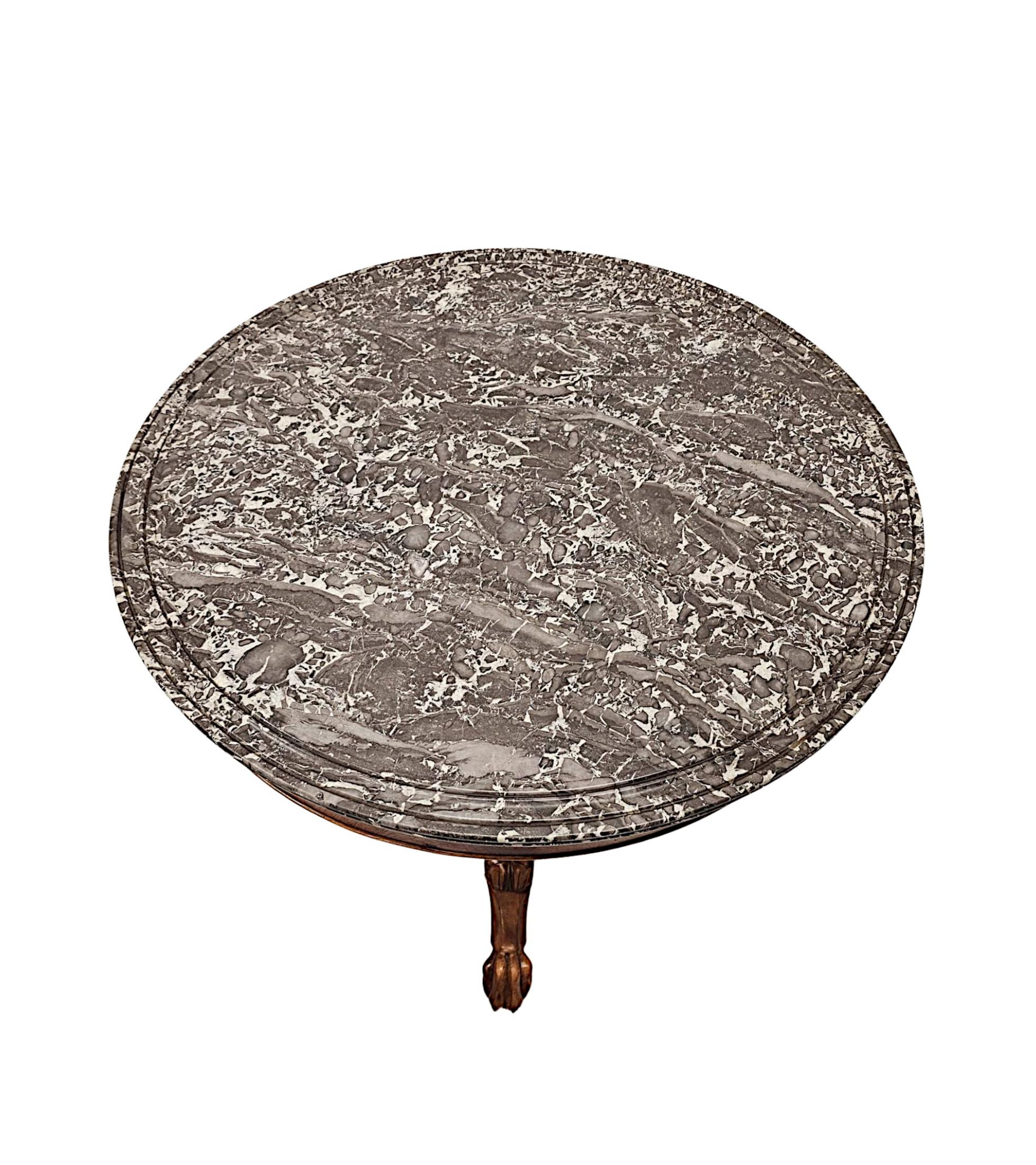 Une superbe table centrale du 19ème siècle en acajou bien figuré, de qualité exceptionnelle et finement sculptée à la main, avec une patine et un grain d'une grande richesse.  Le remarquable plateau moulé en marbre noir Marquina, de forme circulaire