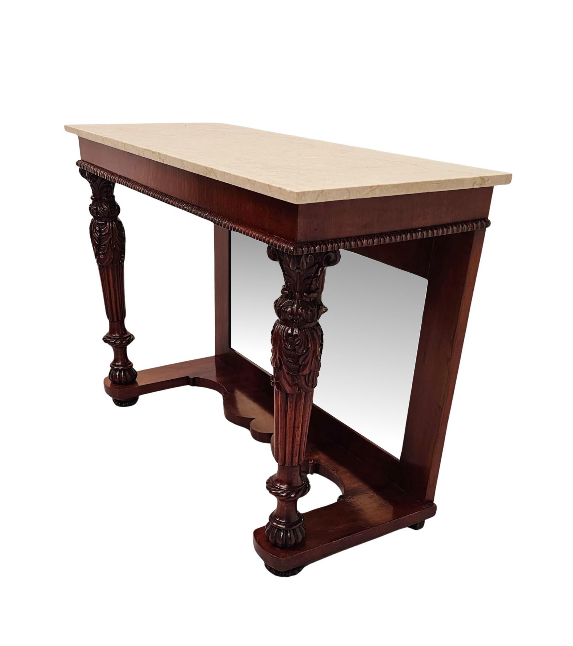 A stunning 19th Century well figured mahogany marble top console table, finely hand carved, of exceptional quality with beautifully rich patination and grain.  The fabulous newer Carrara Marble top of rectangular form is raised over an elegantly