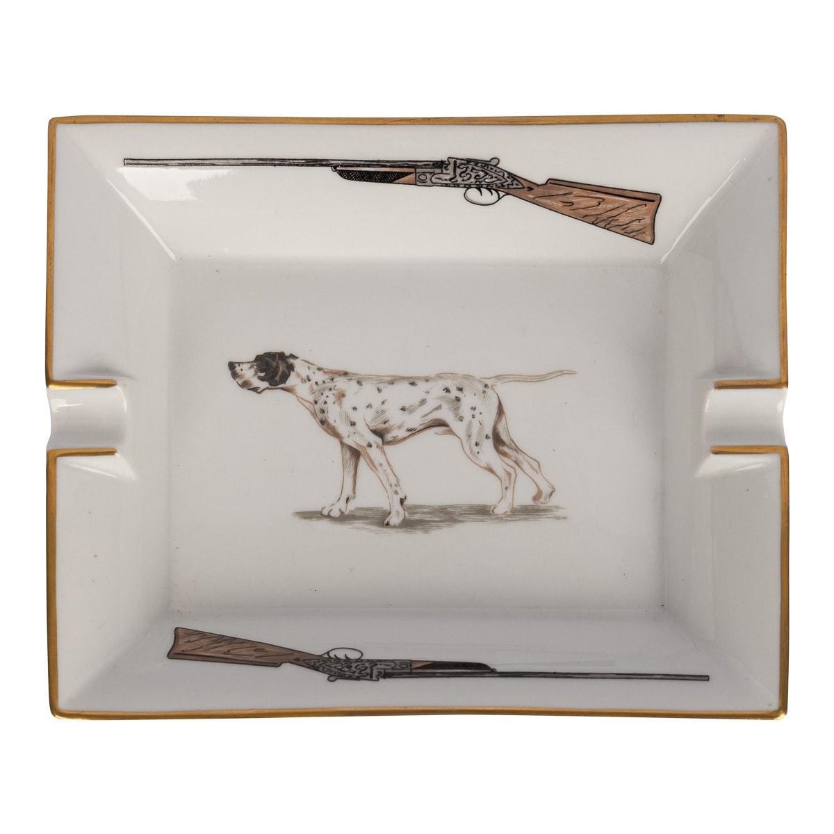 A ceramic ashtray by Hermes, made in France in the latter half of the 20th century. These ashtrays have always been very collectable with the vintage models in particular. This one has a hunting theme, featuring a shotgun and hound, a lovely
