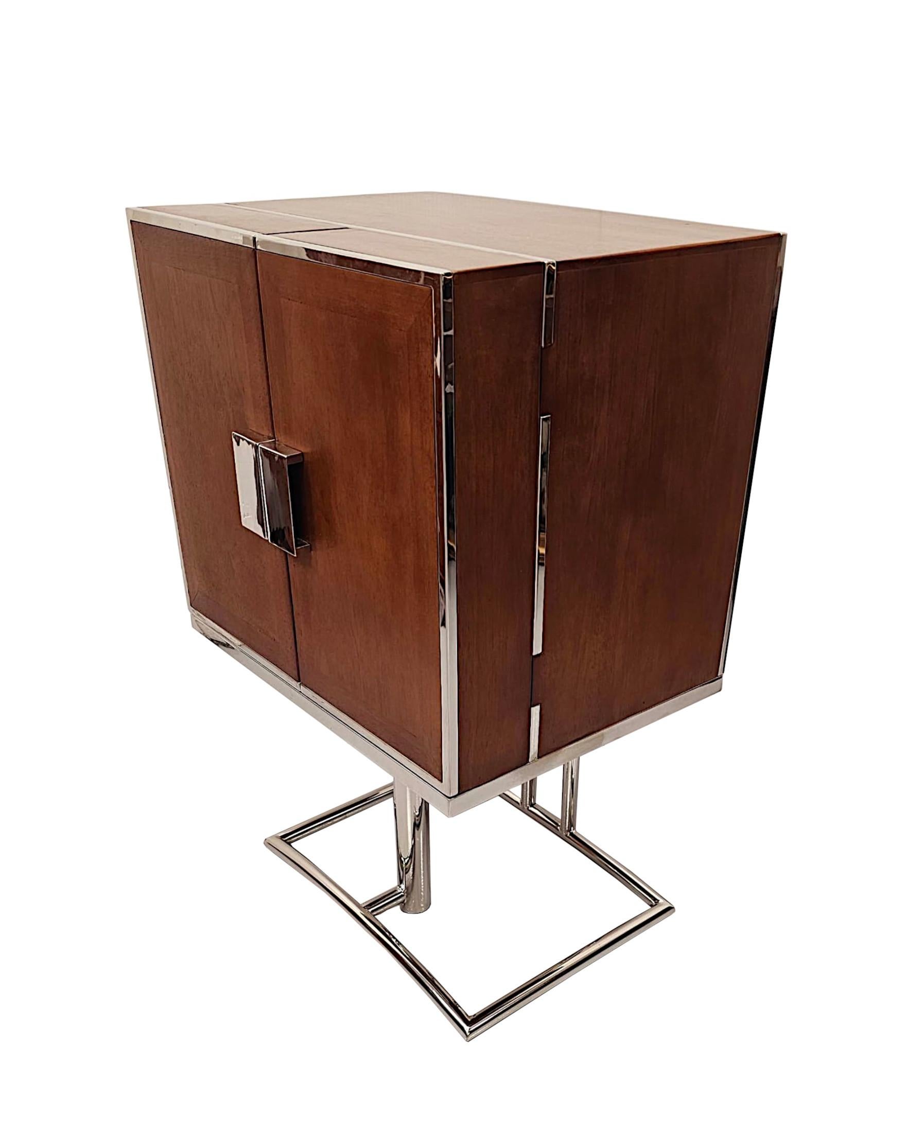 A stunning Art Deco design richly patinated cherrywood drinks cabinet, finely carved, of exceptional quality with a striking clean simple design and with chrome detail throughout.  The finely figured moulded top of rectangular form is raised over