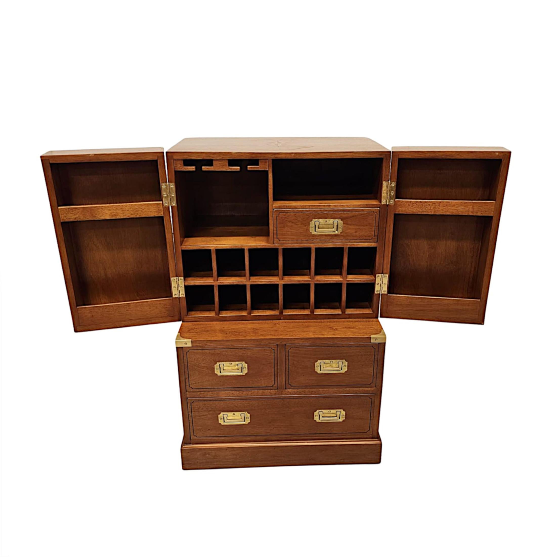 A stunning cherrywood and brass bar cabinet of exceptional quality, richly patinated and beautifully hand made with finely cast brass mounts throughout.  The well figured moulded top of the upper section with gorgeous marquetry inlaid star motif