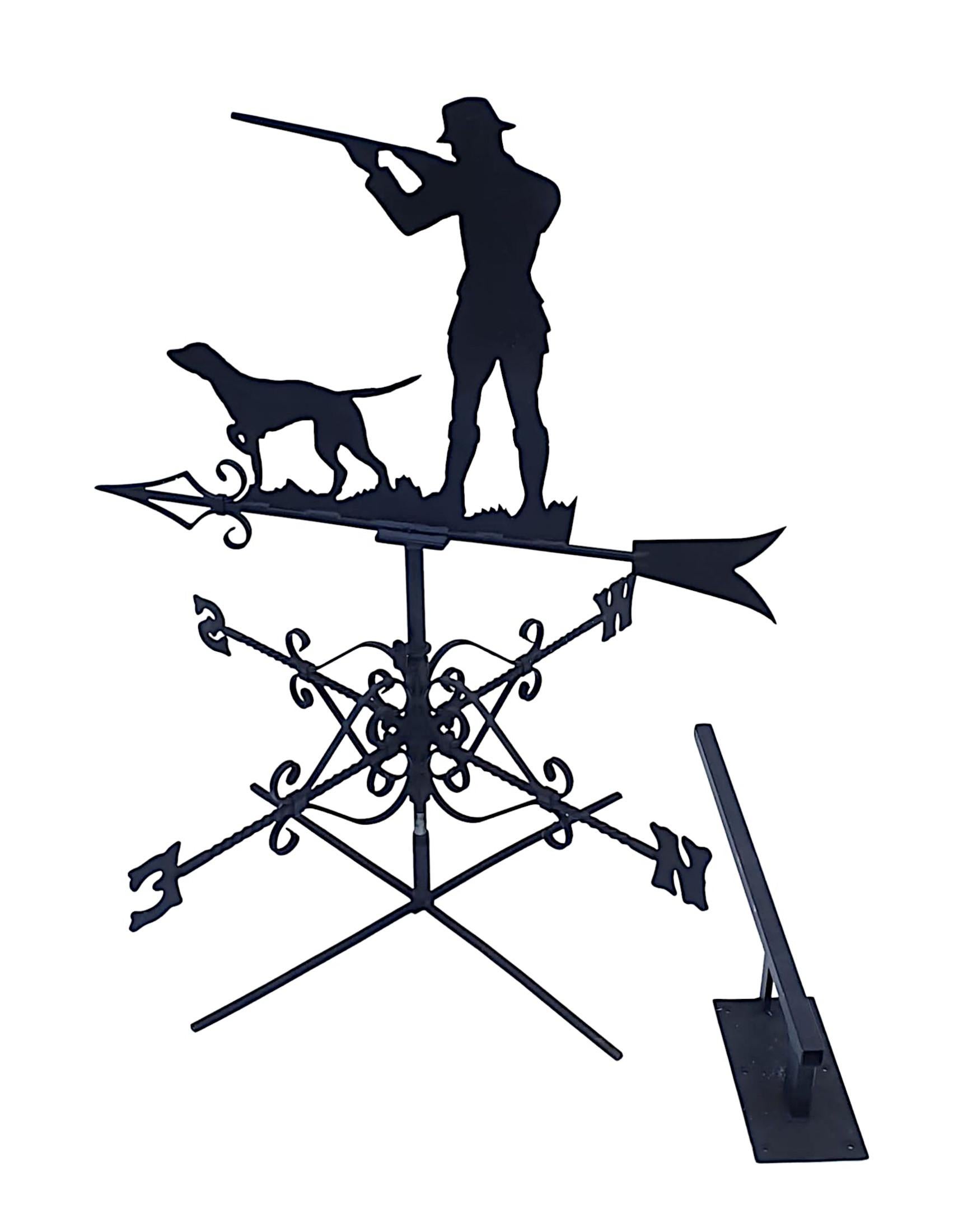 A stunning mid 20th century forge made galvanised metal weather vane, the ornament depicting a classic silhouette of a gun man and his dog, raised over lovely directionals with fine scroll detail.
