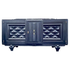 A stunning French 1940s ebonised oak sideboard with detailed relief doors.