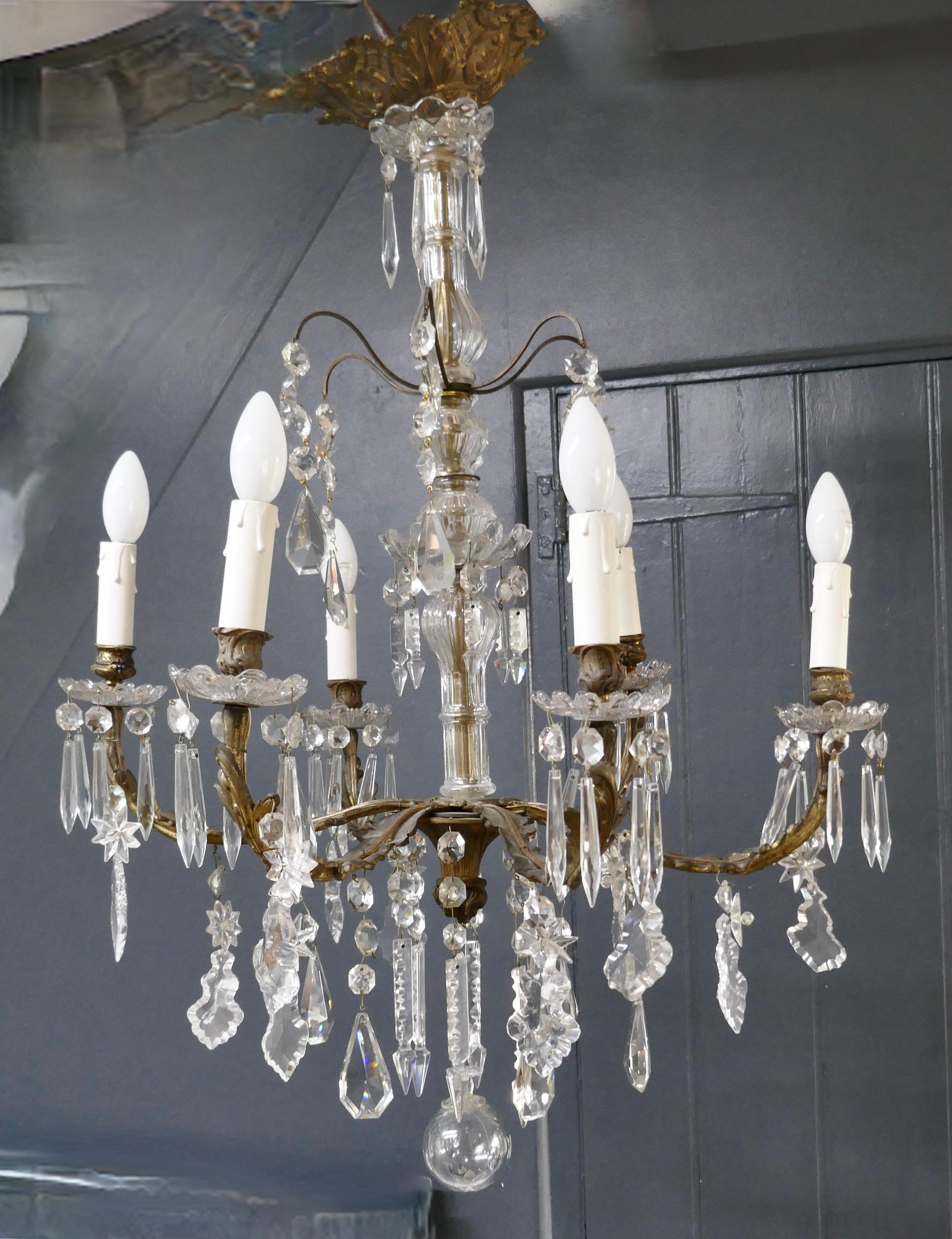 A stunning French cristal 6 branch brass chandelier

This is a superb brass chandelier, the centre baluster is covered with glass and at the end of each branch there are double glass sconces profusely hung with icicles, stars and pear shaped