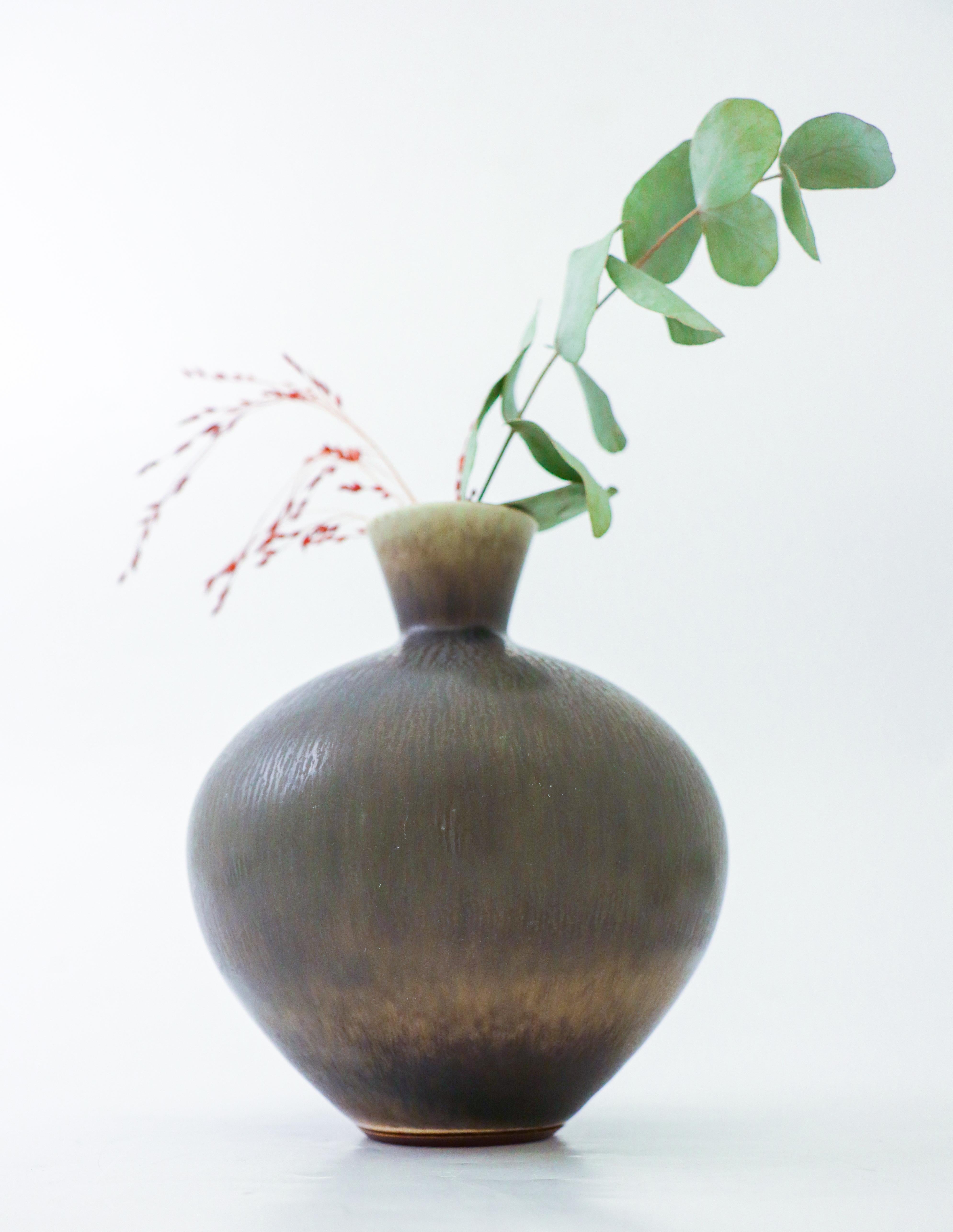 Ce vase gris, conçu par Berndt Friberg chez Gustavsberg à Stockholm, mesure 15,5 cm de haut et environ 13 cm de diamètre. Il a une belle glaçure de fourrure brune, il est marqué comme sur la photo. Ce vase a été produit en 1977, il est en excellent