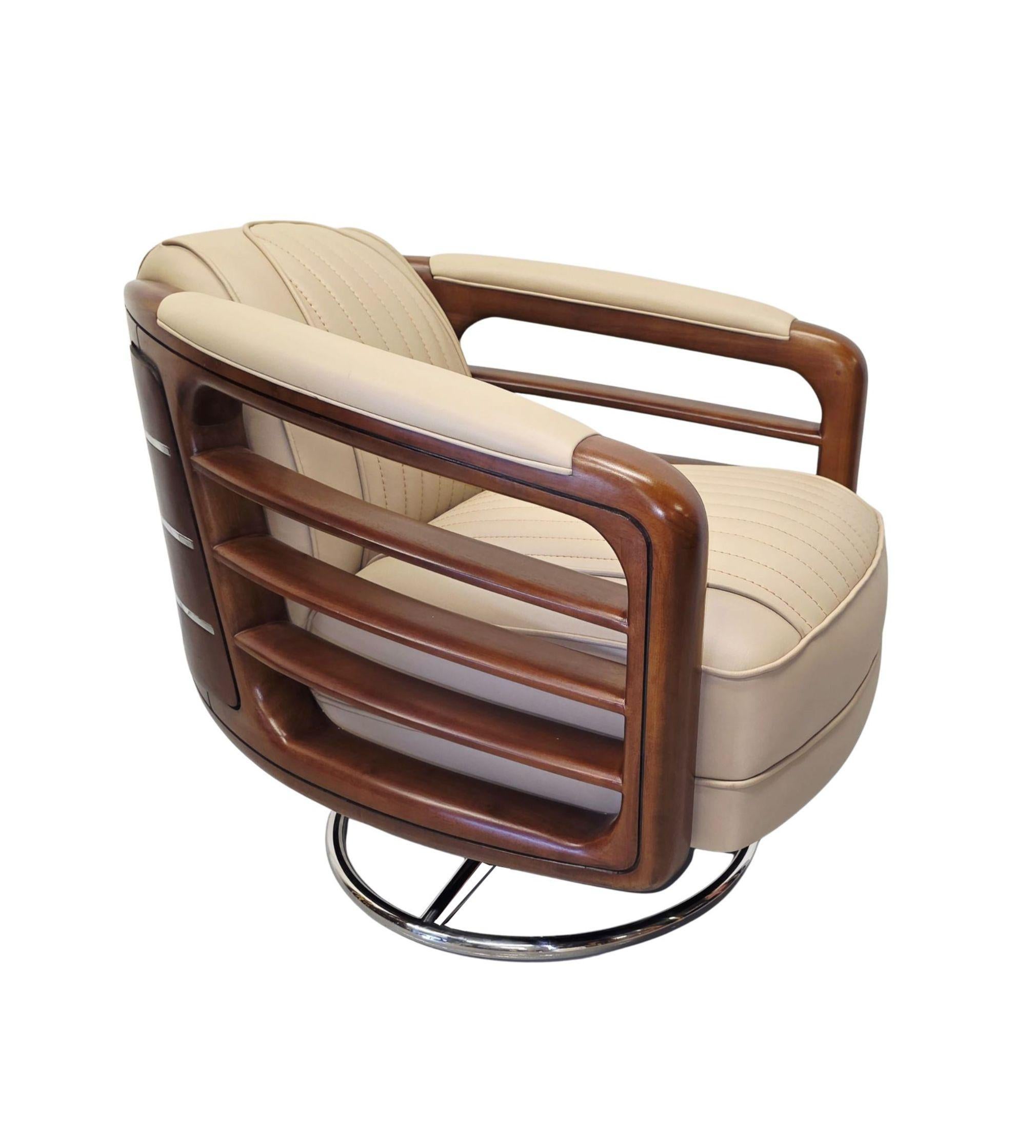 A stunning Art Deco design finely carved and richly patinated walnut, leather and chrome revolving armchair of exceptional quality.  This fabulous piece is beautifully upholstered in elegant cream leather with innovative horizontal stitch detail and