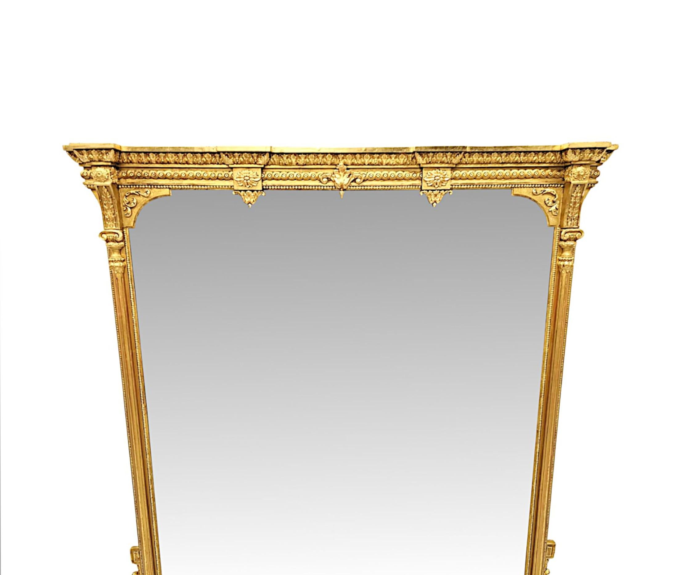 Splendido specchio in legno dorato del XIX secolo, di proporzioni grandiose e di qualità eccezionale.  La lastra di vetro a specchio, di forma rettangolare con angoli superiori curvi e dettagli a volute, è incastonata in una cornice in legno dorato