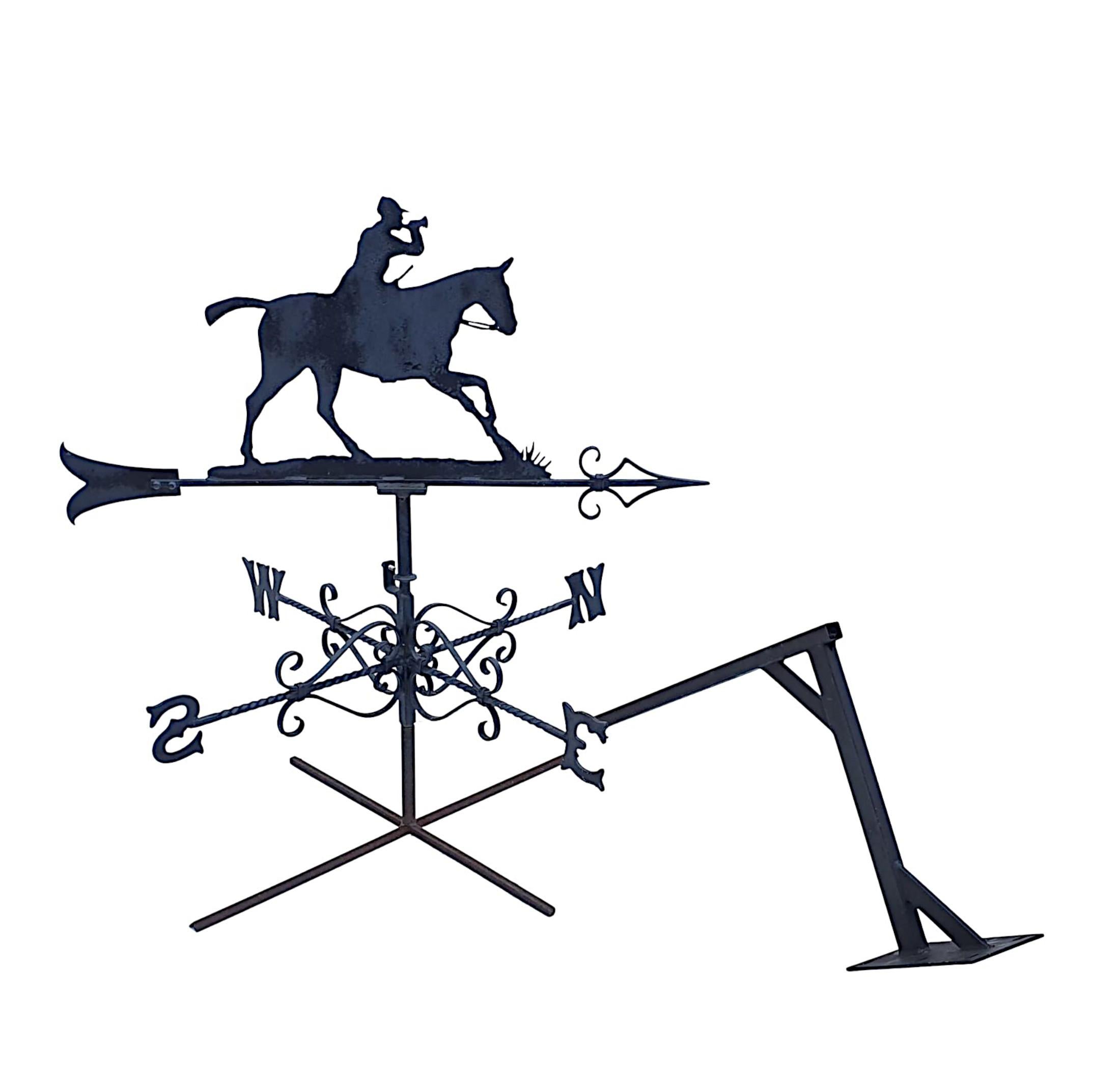A stunning mid 20th century forge made galvanised metal weather vane, the ornament depicting a classic silhouette of a hunter on his horse, raised over lovely directionals with fine scroll detail.
