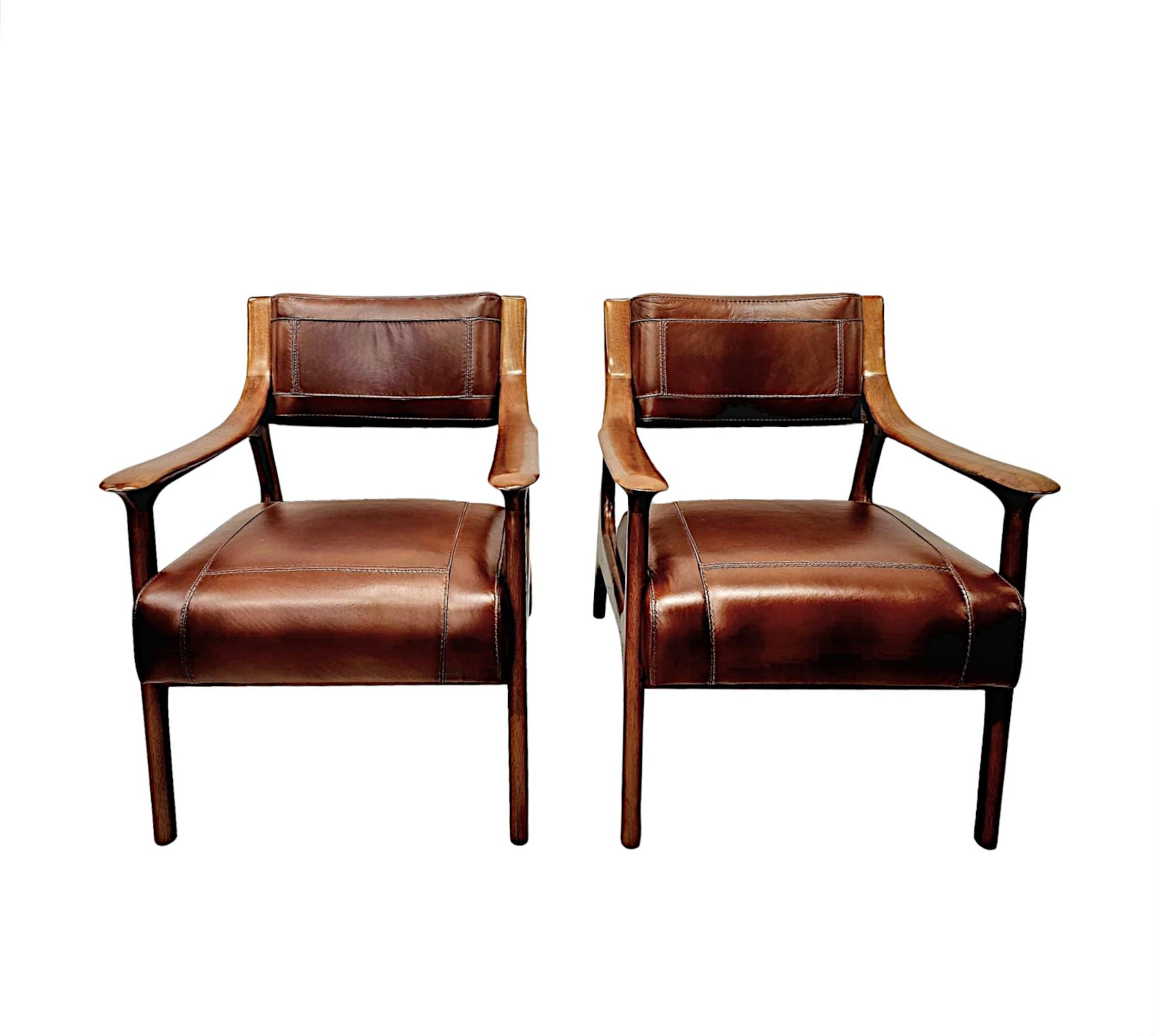 Una splendida poltrona di Mid Century Design finemente intagliata e modellata in ciliegio con cornice in pelle di qualità eccezionale, con una patina e una venatura meravigliosamente ricche.  Lo schienale e la seduta imbottiti sono rivestiti in