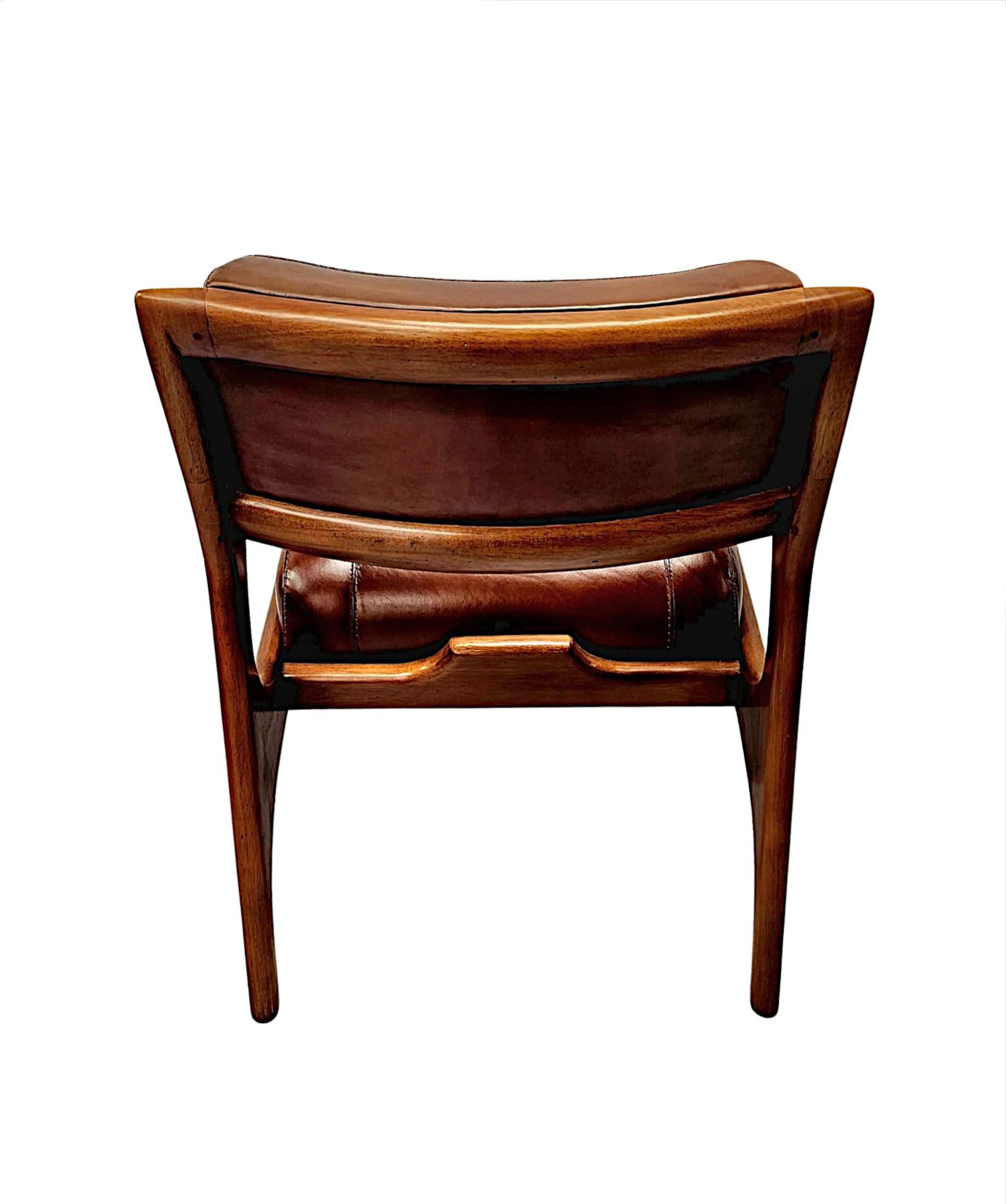 Pelle Una splendida poltrona in pelle e ciliegio dal design di metà secolo in vendita