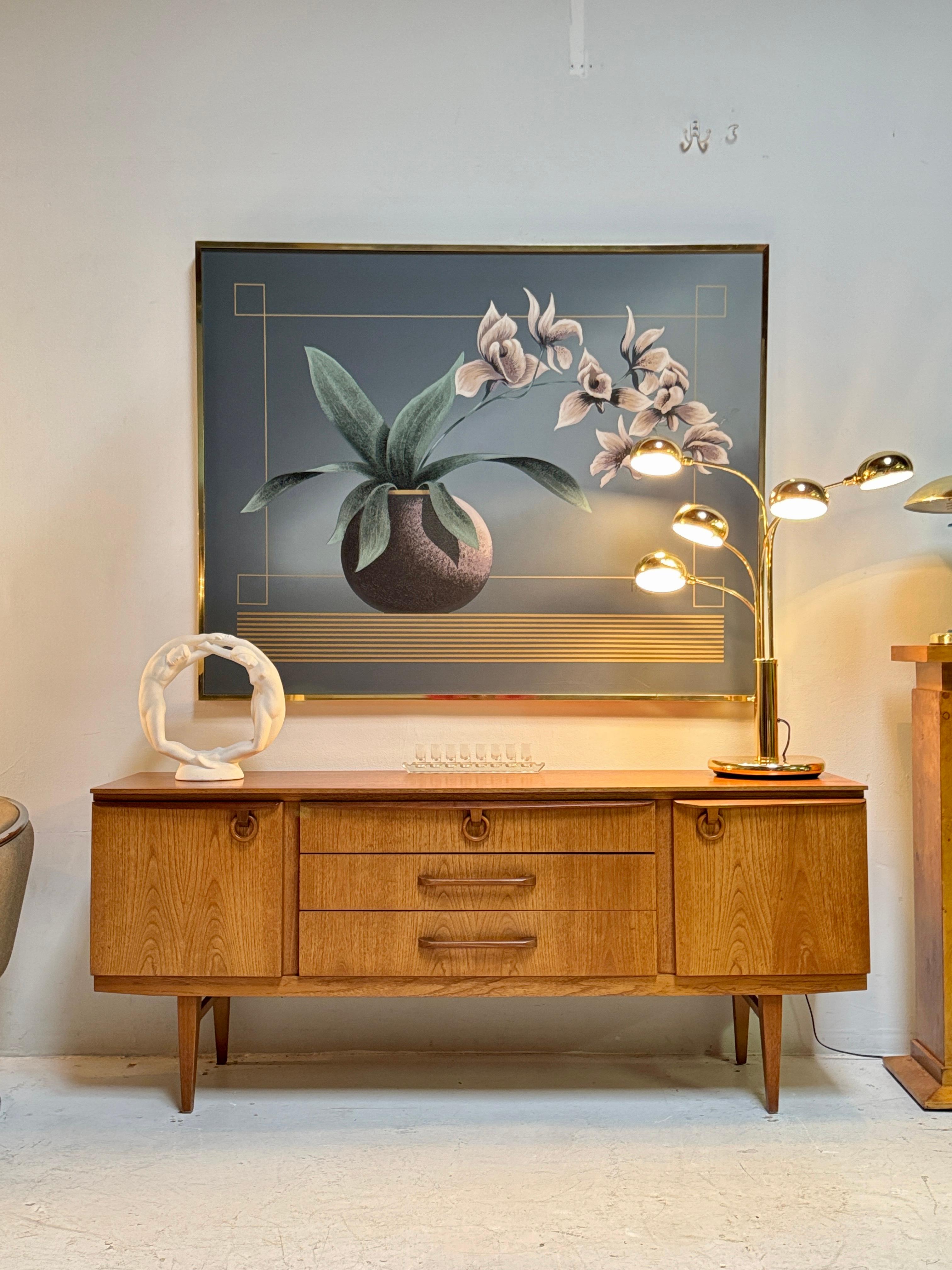 Ein atemberaubendes Sideboard aus Teakholz von Beautility aus der Mitte des Jahrhunderts, ca. 1960er Jahre. Eine zeitlose Mischung aus Form und Funktion.
Seine schlanke Silhouette, gepaart mit klaren Linien und konisch zulaufenden Beinen, strahlt