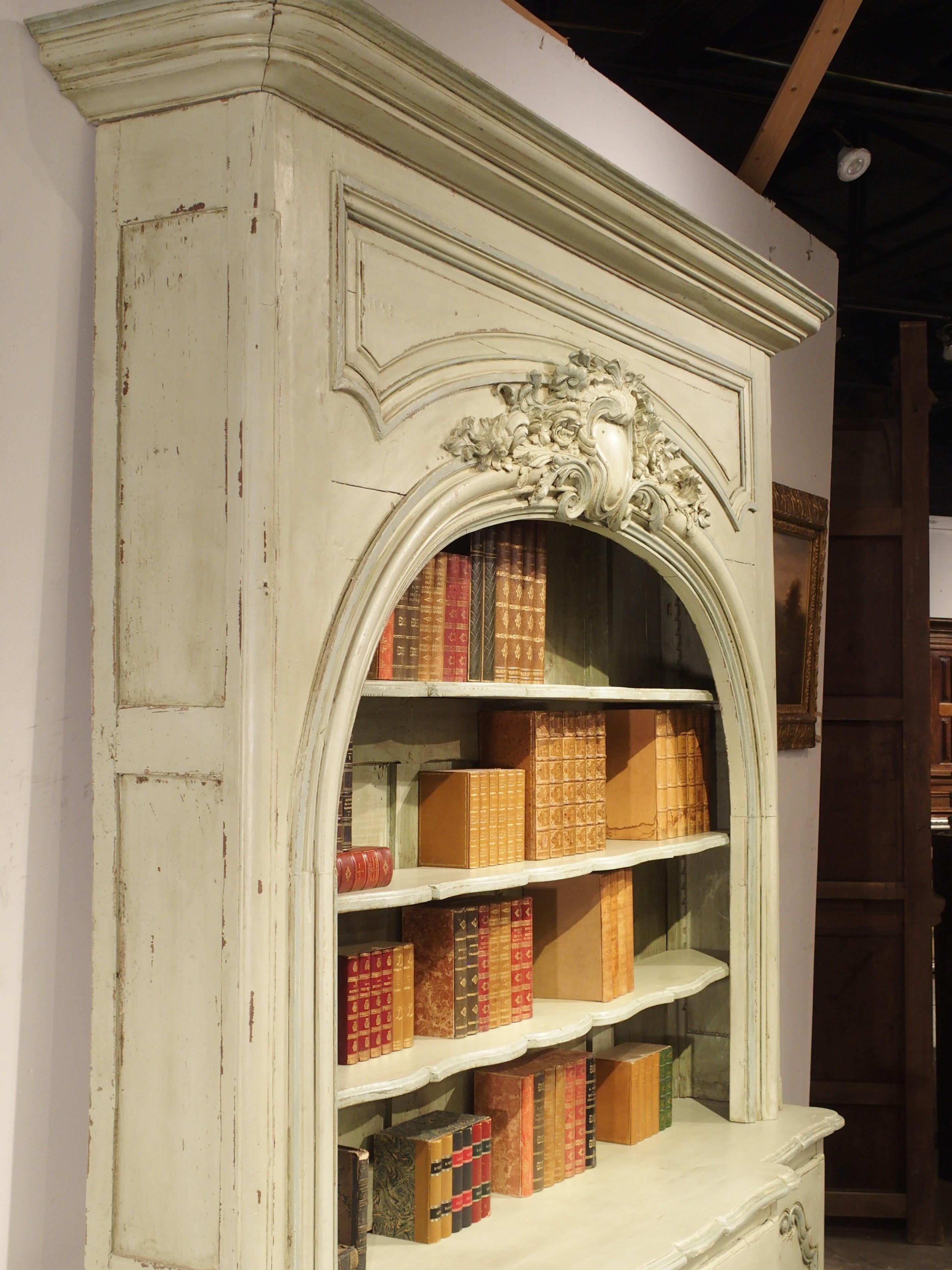 This stunning painted bibliotheque most recently came from a chateau in the Lauragais region, in the southwest of France. The bookcase is realized from antique polychrome gray-green elements and features a beautiful arched opening which is crowned
