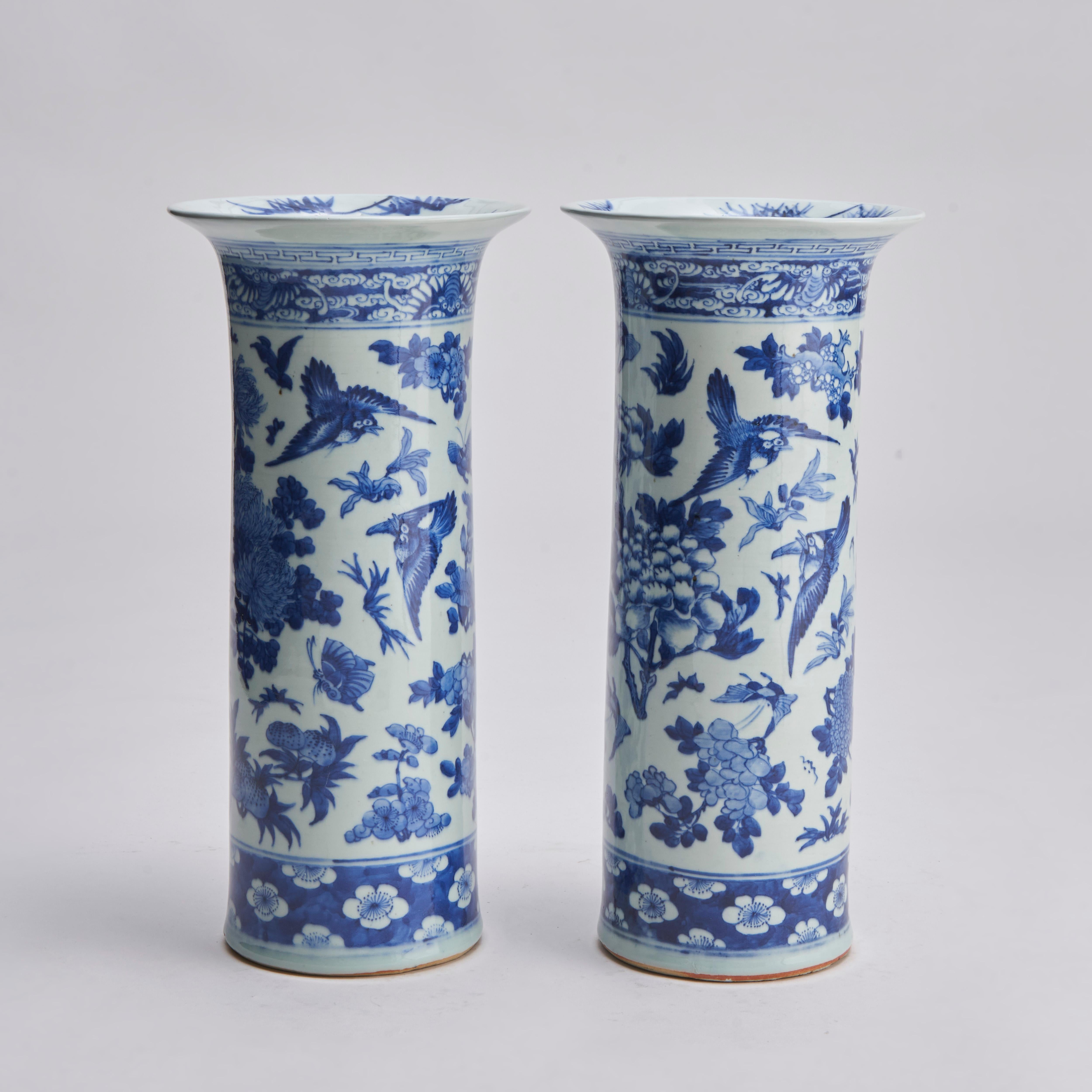 A pair of 19th century Chinese blue and white flare-rimmed sleeve vases with decoration of many flowers including peonies and hydrangeas. Surrounded by butterflies and song-birds, the foot with a hawthorn blossom patten, the top with a panel of bats