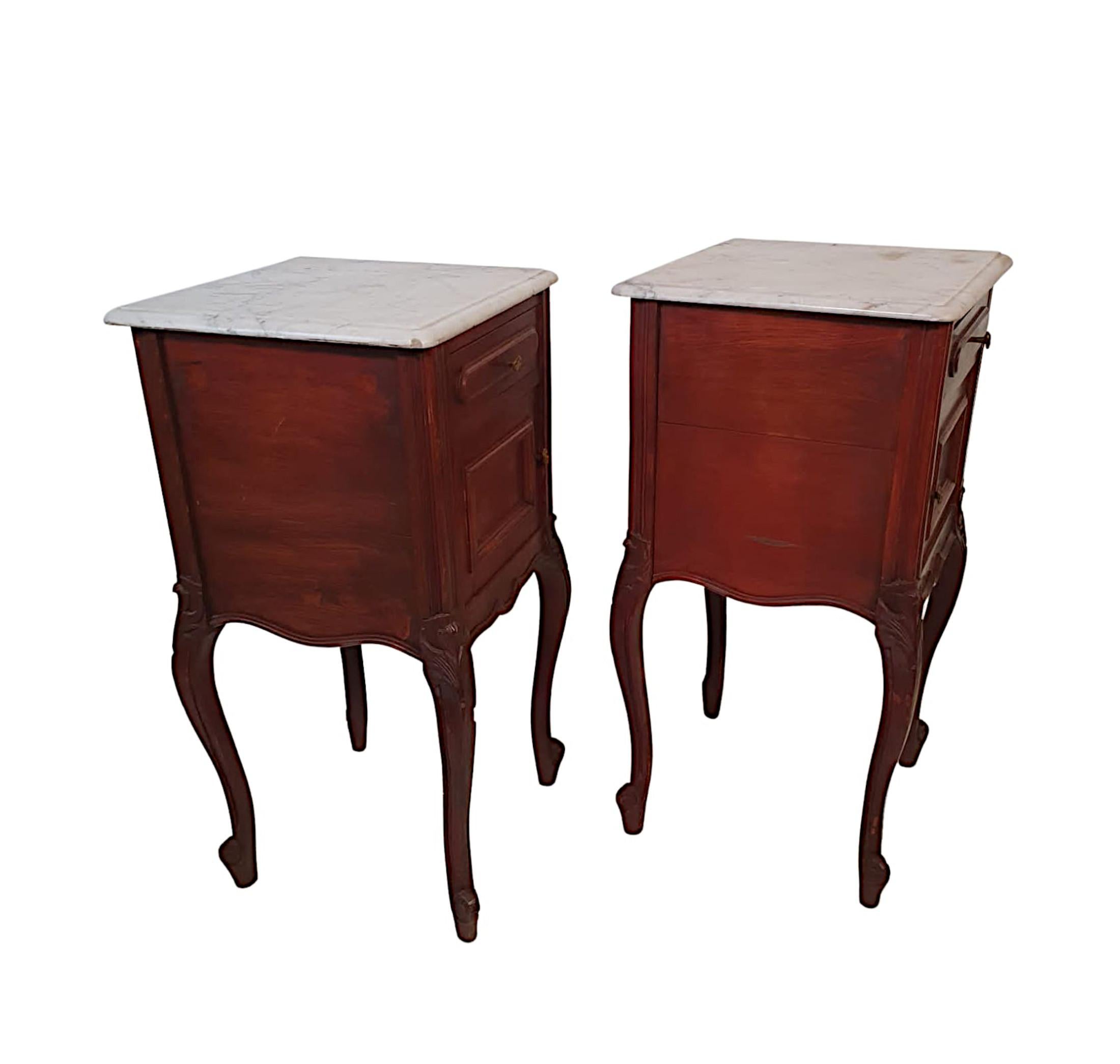 A stunning pair of 19th Century French mahogany bedside lockers.  The moulded Carrara white marble top raised over panelled frieze with single drawer raised over panelled cupboard door, both with ornate brass pulls.  The shaped serpentine apron to
