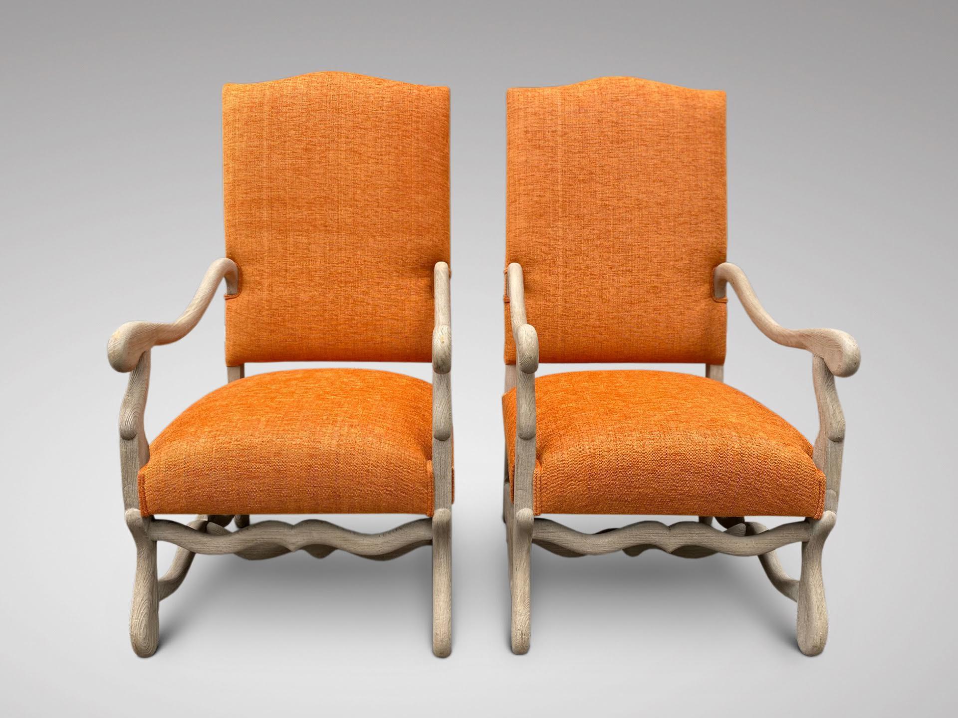Une superbe paire de fauteuils anciens en noyer français du 19ème siècle, de style Louis XIV, remeublés dans un tissu de qualité de couleur orange. Les bras sont façonnés et reposent sur d'élégants pieds en forme de volute unis par un brancard