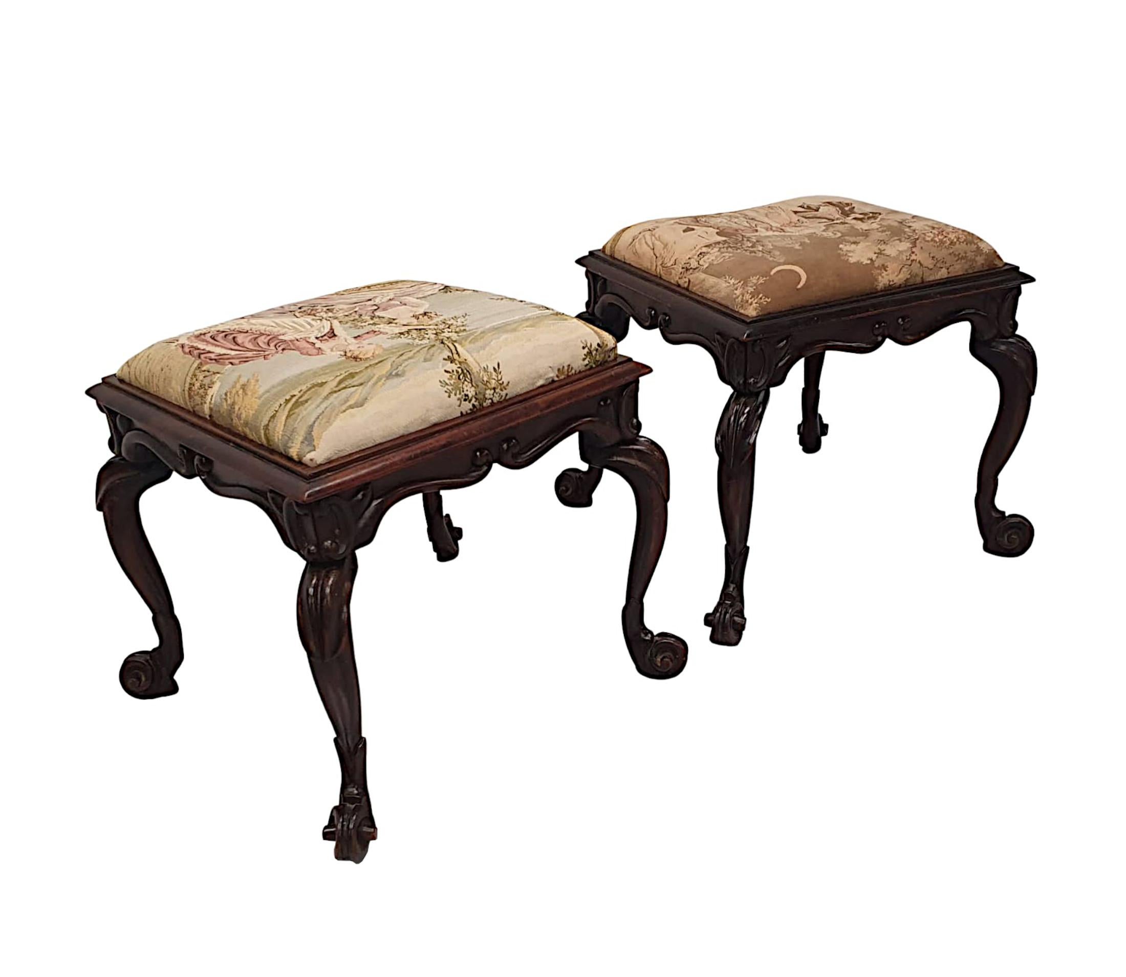 A stunning pair of 19th Century simulated fruitwood stools.  The moulded tops of square form, upholstered with intricate tapestry cushioned seats depicting beautiful scenes of lords and ladies in hues of pinks, greens, blues and purples, set within