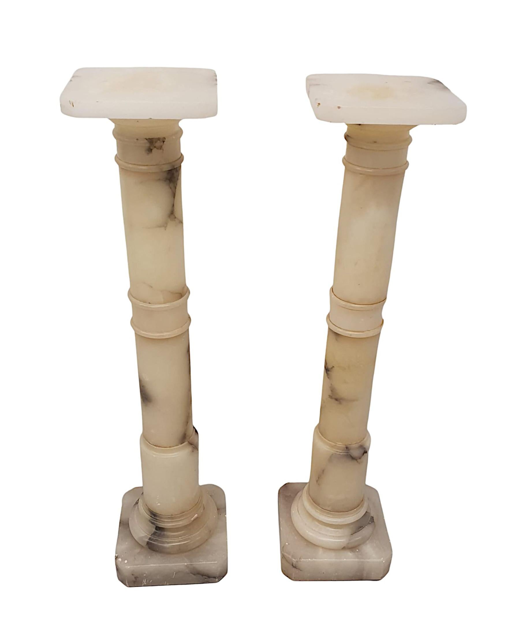 A stunning pair of early 20th Century Italian, finely hand carved alabaster bust or plant stands in the Neoclassical manner. The moulded top of octagonal form raised over elegant, ring turned gun barrel column, supported on octagonal plinth base.